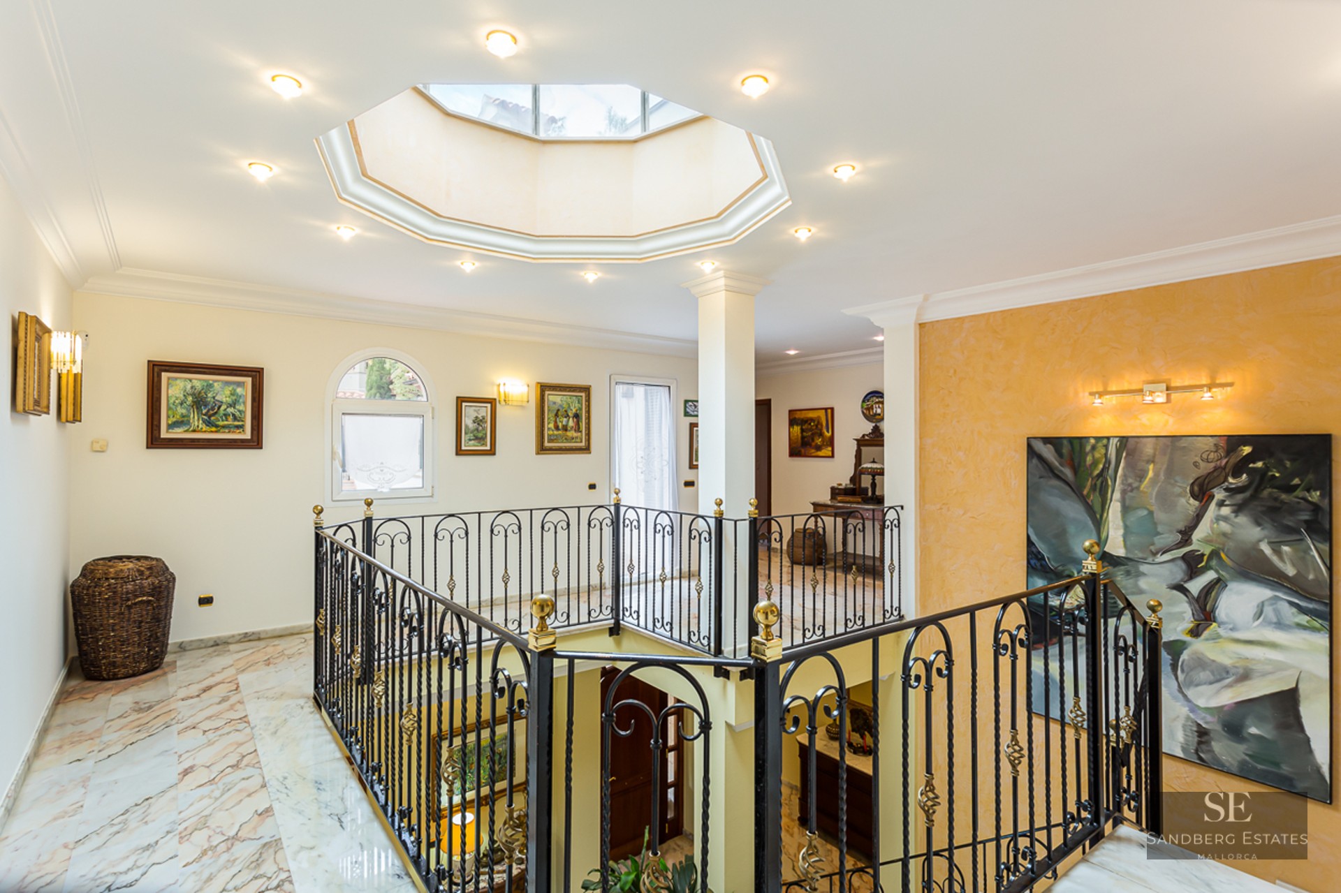 Interior landing with marble floors, a wrought iron railing, and an octagonal skylight in the ceiling.