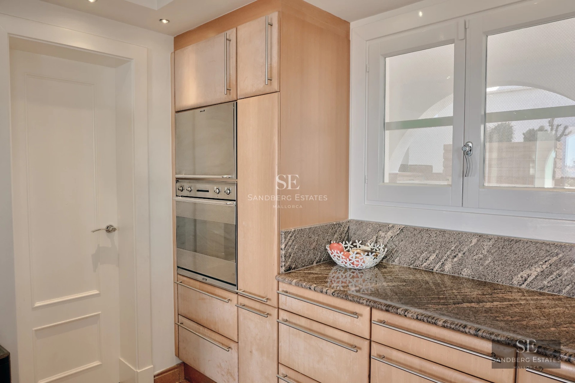 Spacious balcony with sea view. Modern design featuring glass railings and comfortable outdoor furniture.