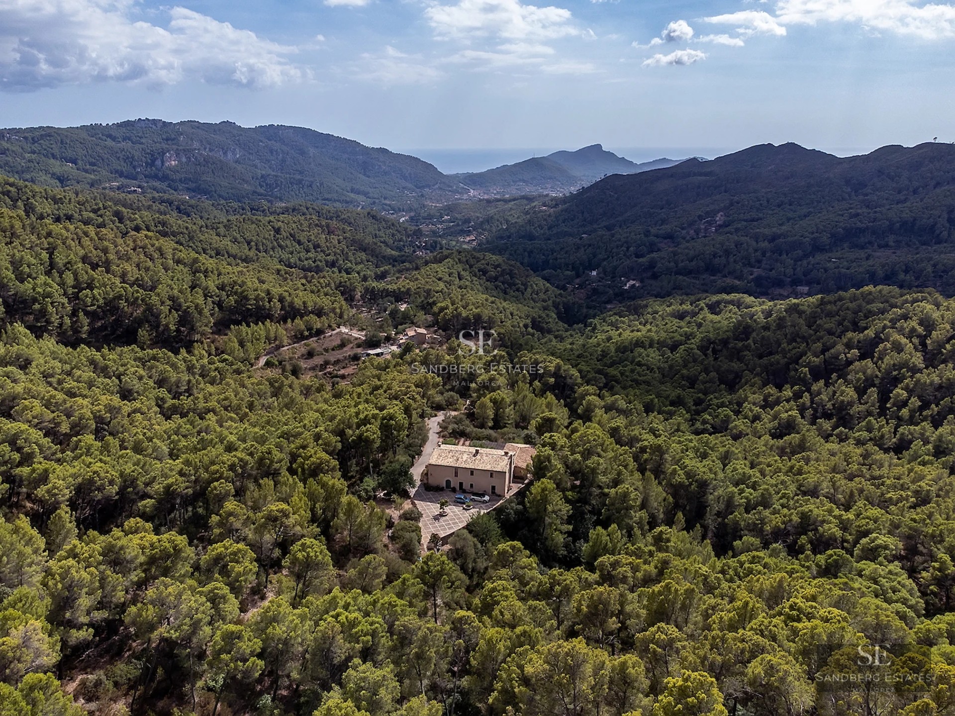 Exterior view of a modern villa featuring an infinity pool, lush garden, and spacious terraces. Minimalist architectural design with large windows.