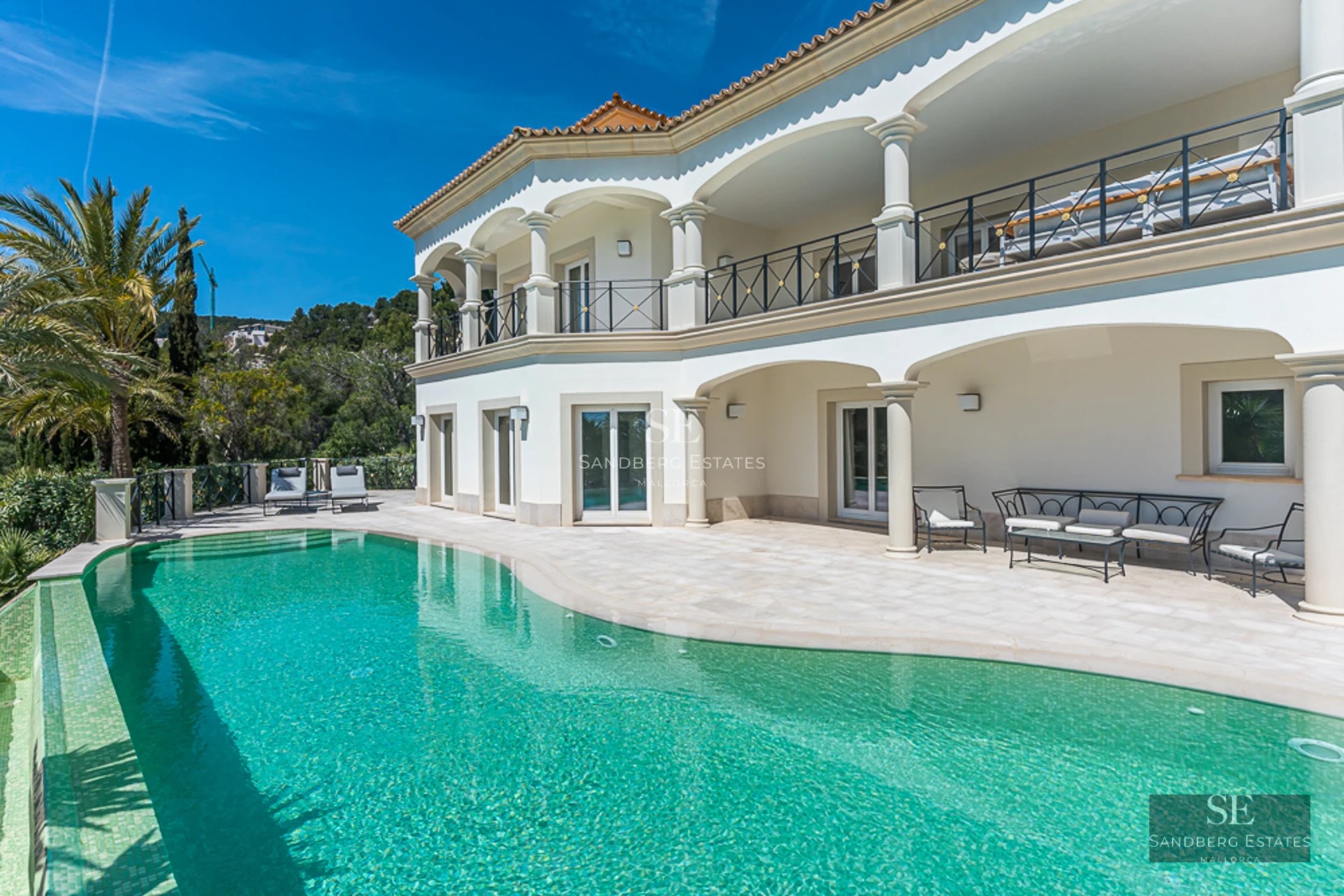 Exterior view of a luxurious apartment featuring a pool, terrace with sun loungers, and green spaces. Sleek modern design with soft lighting.