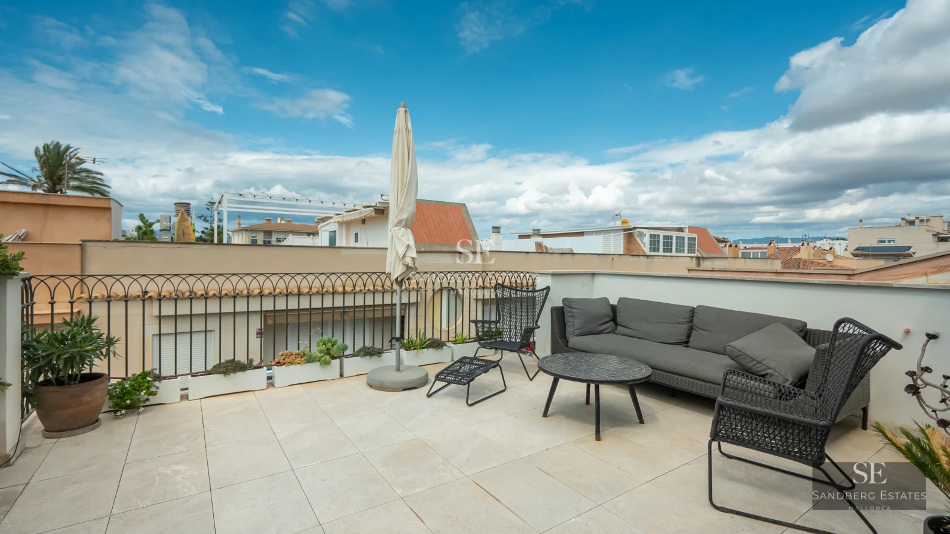 Modern balcony featuring panoramic sea views. Glass railing, light wood flooring, and minimalist furniture. Soft, natural lighting.