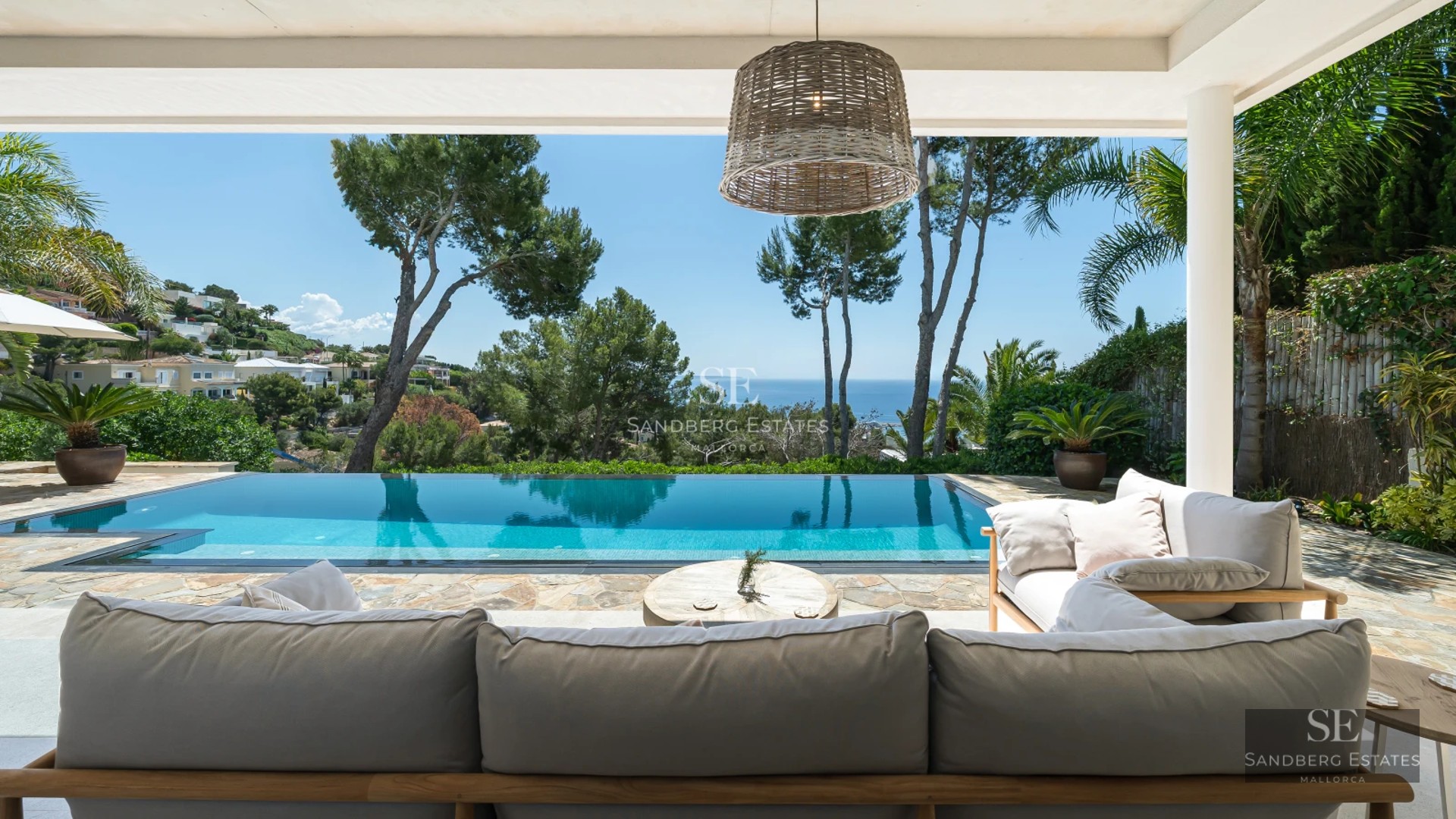 Exterior view of a modern home with infinity pool, manicured garden, and spacious terraces. Minimalist design and high-quality finishes.