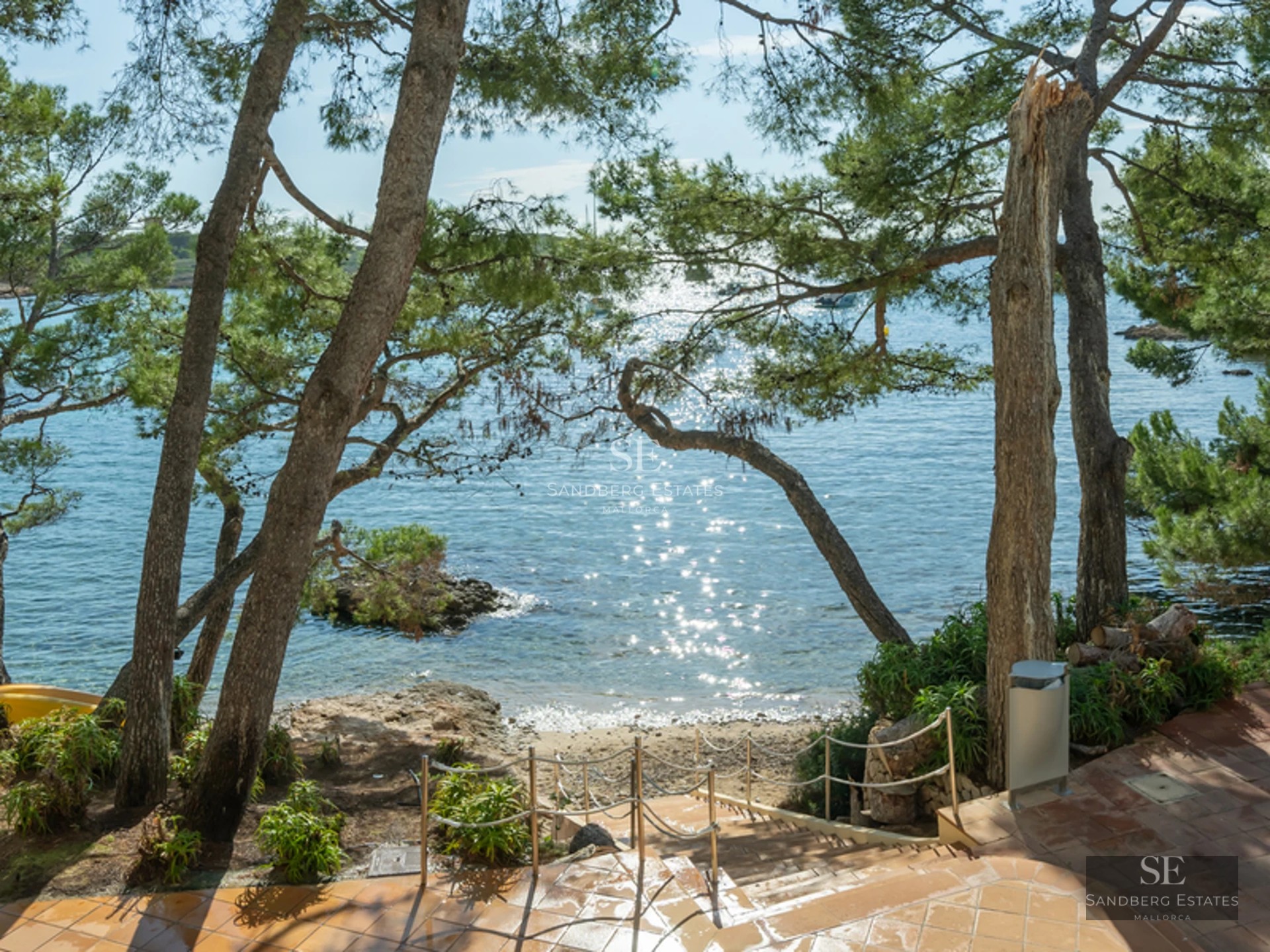 Spacious living room featuring floor-to-ceiling windows, light wood floors, a modern fireplace, and garden views. Minimalist and bright design.