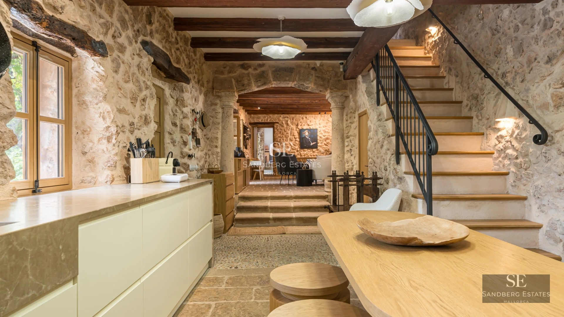 View of a luxurious pool with sun loungers and umbrellas, surrounded by a sleek modern villa and a lush garden.