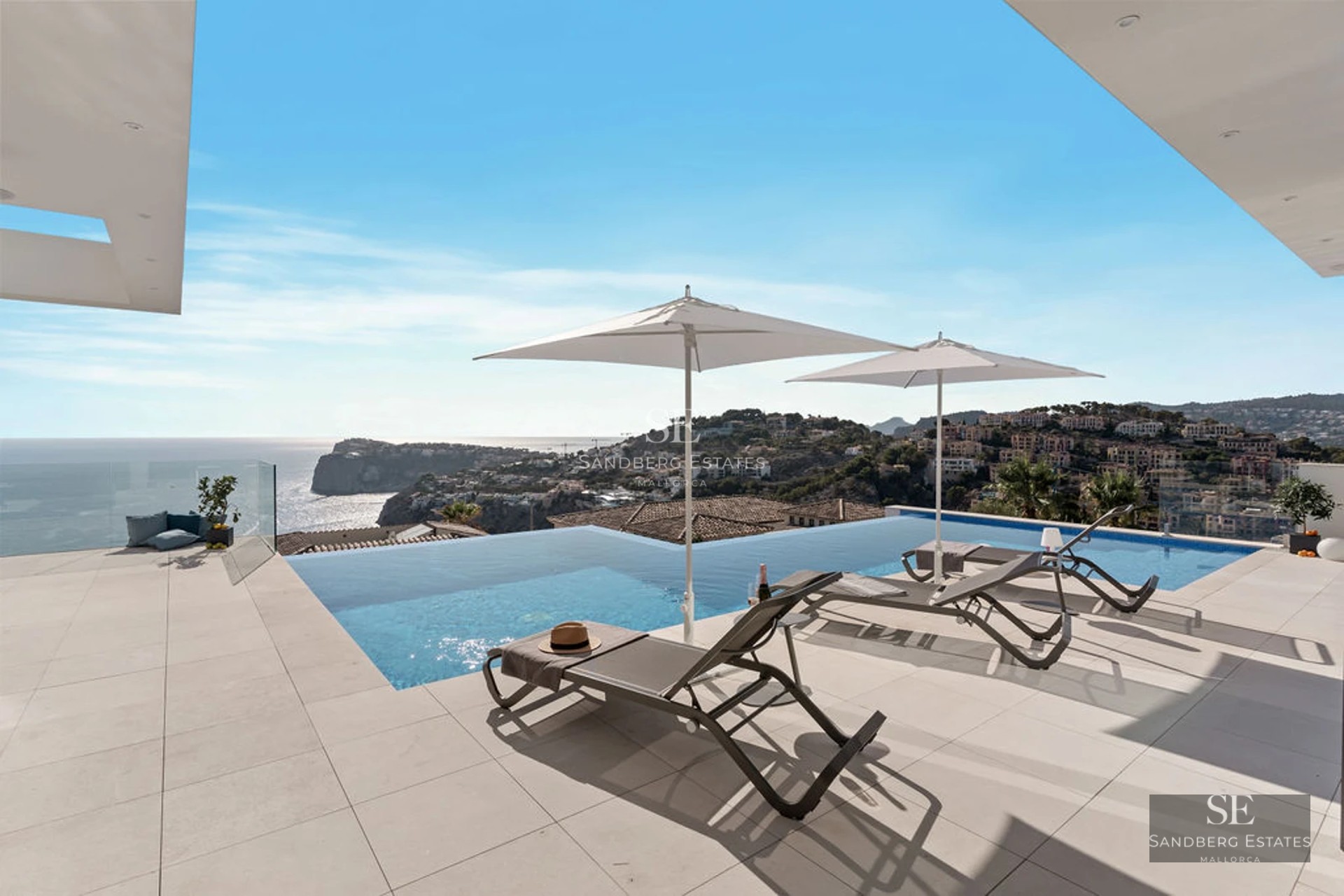 Exterior view of a modern villa with a pool, terrace, and expansive garden. Minimalist architecture with large windows.