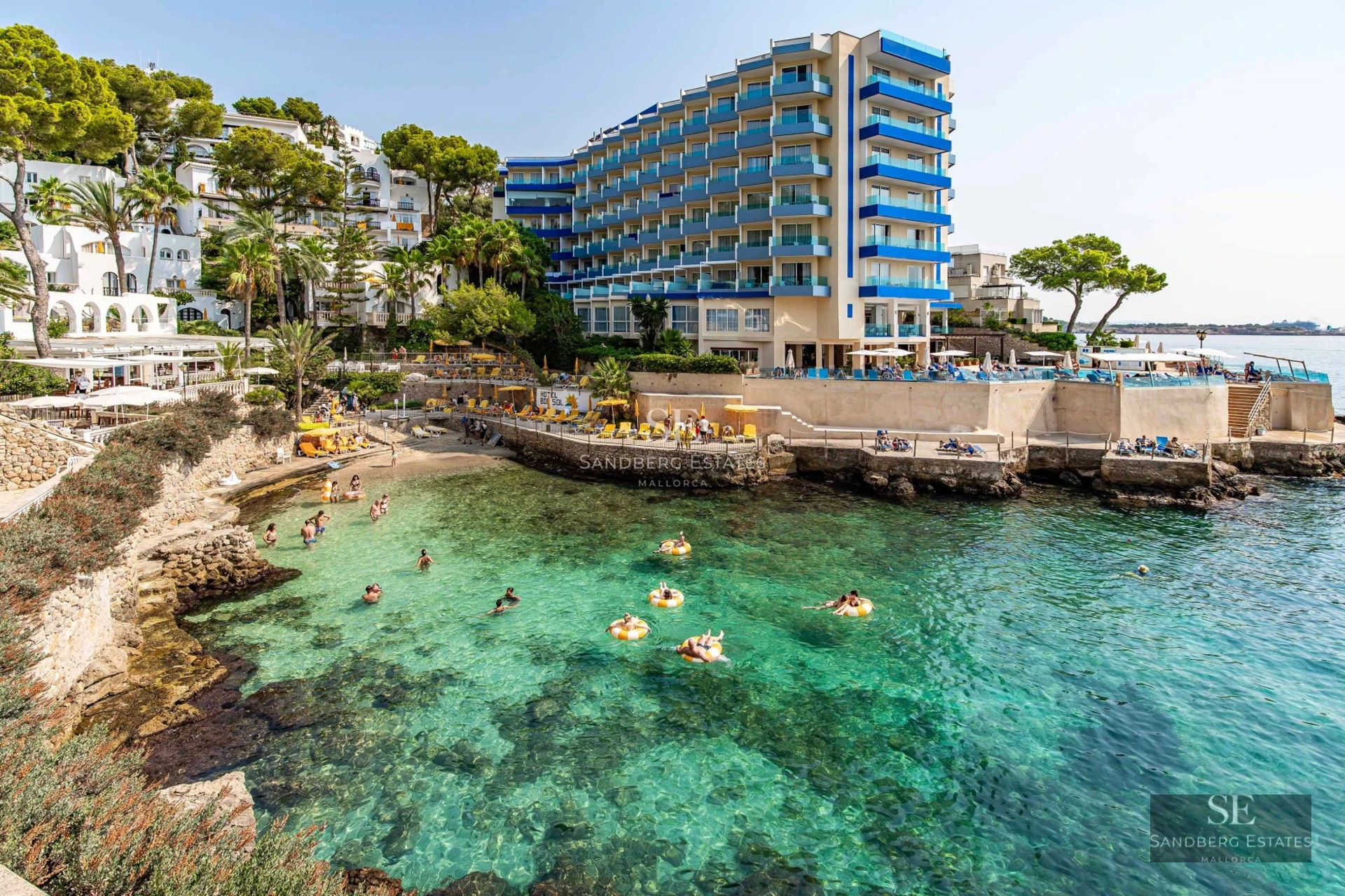 Exterior view of property with pool. Modern architecture, large windows, lush garden and shimmering pool under the sun.