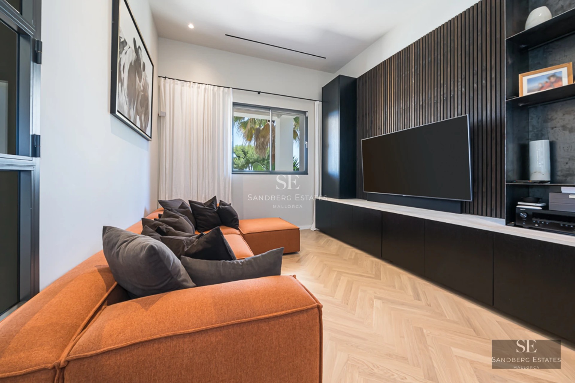 Salon spacieux avec de grandes baies vitrées, canapés gris, table basse moderne et vue imprenable sur la mer. Abondance de lumière naturelle.