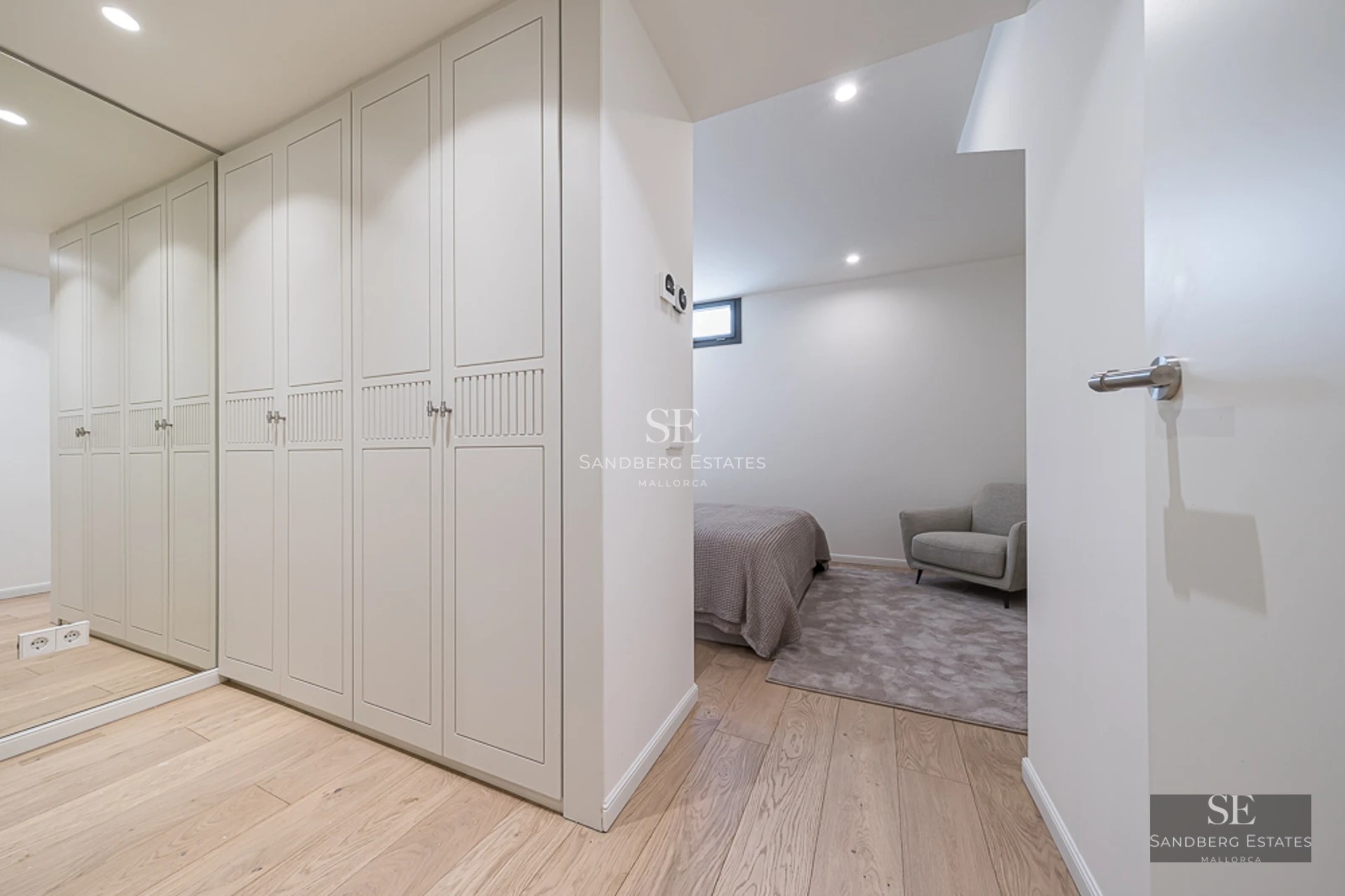 Spacious balcony overlooking the sea. Elegant outdoor furniture and minimalist design. Wooden flooring and glass railing.