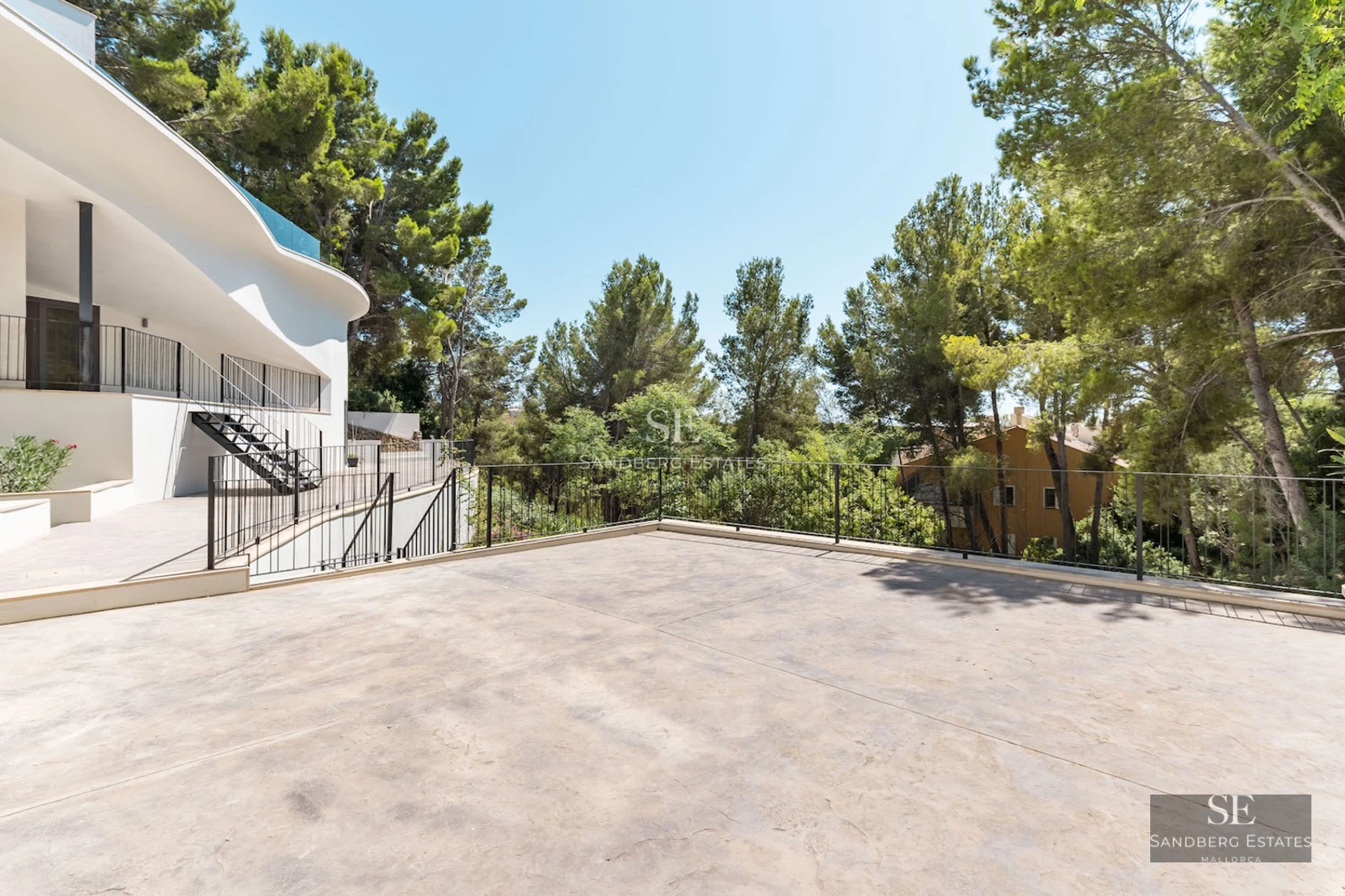Panoramic view of a modern villa with infinity pool, large garden, and minimalist architectural design featuring large windows.