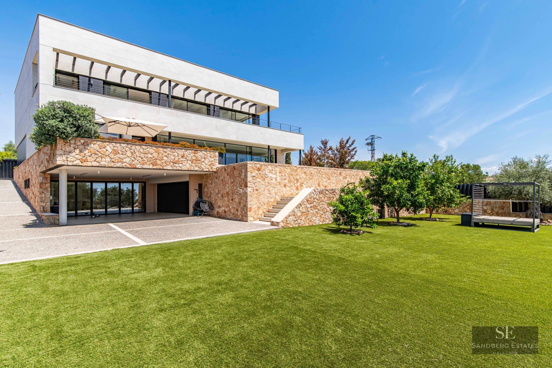 Spacious terrace with infinity pool and sea view. Modern architecture with stylish furniture. Sun loungers and umbrellas.