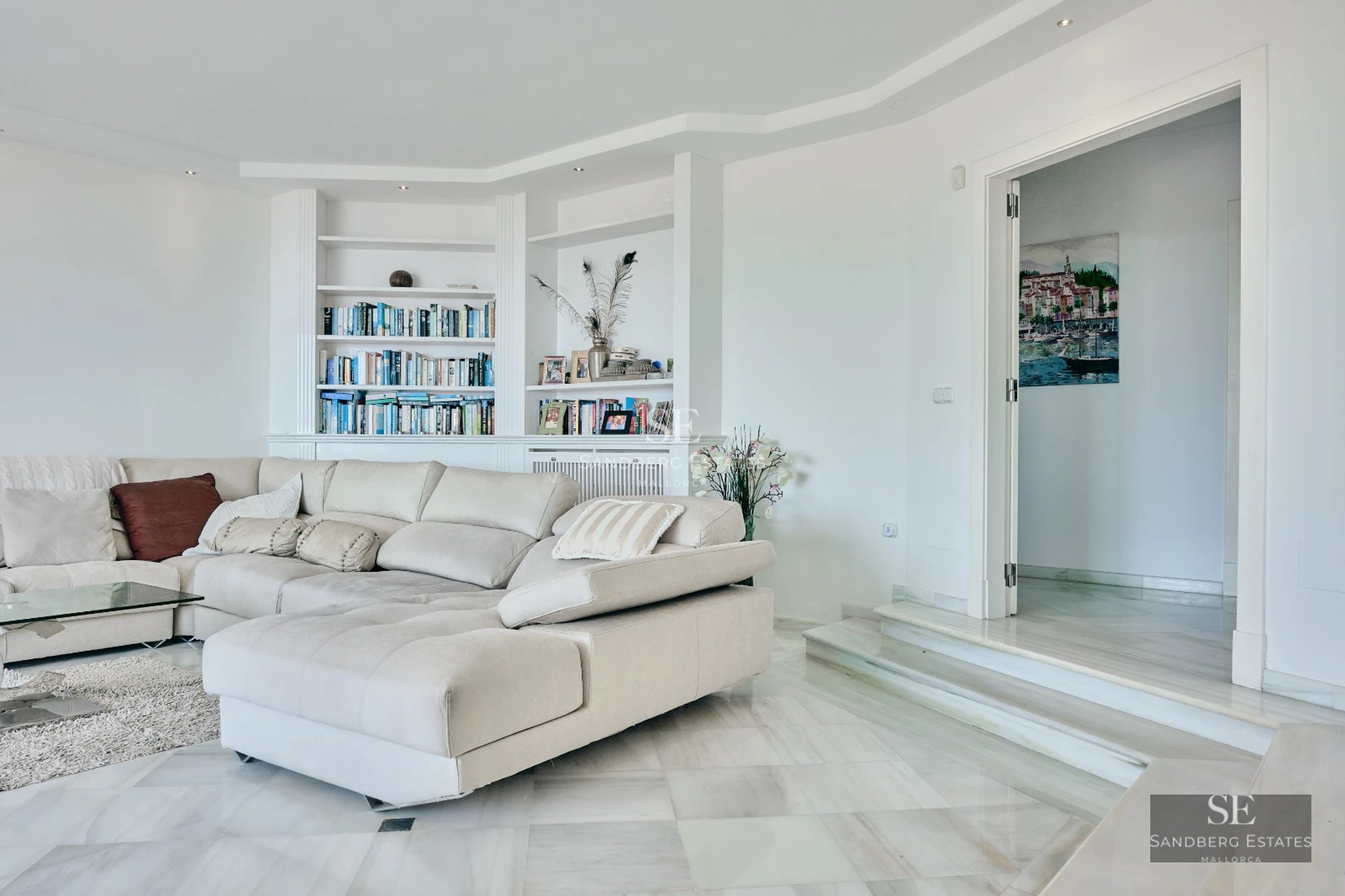 View of a modern pool with a minimalist design villa in the background. Large windows, terraces, and lush vegetation.