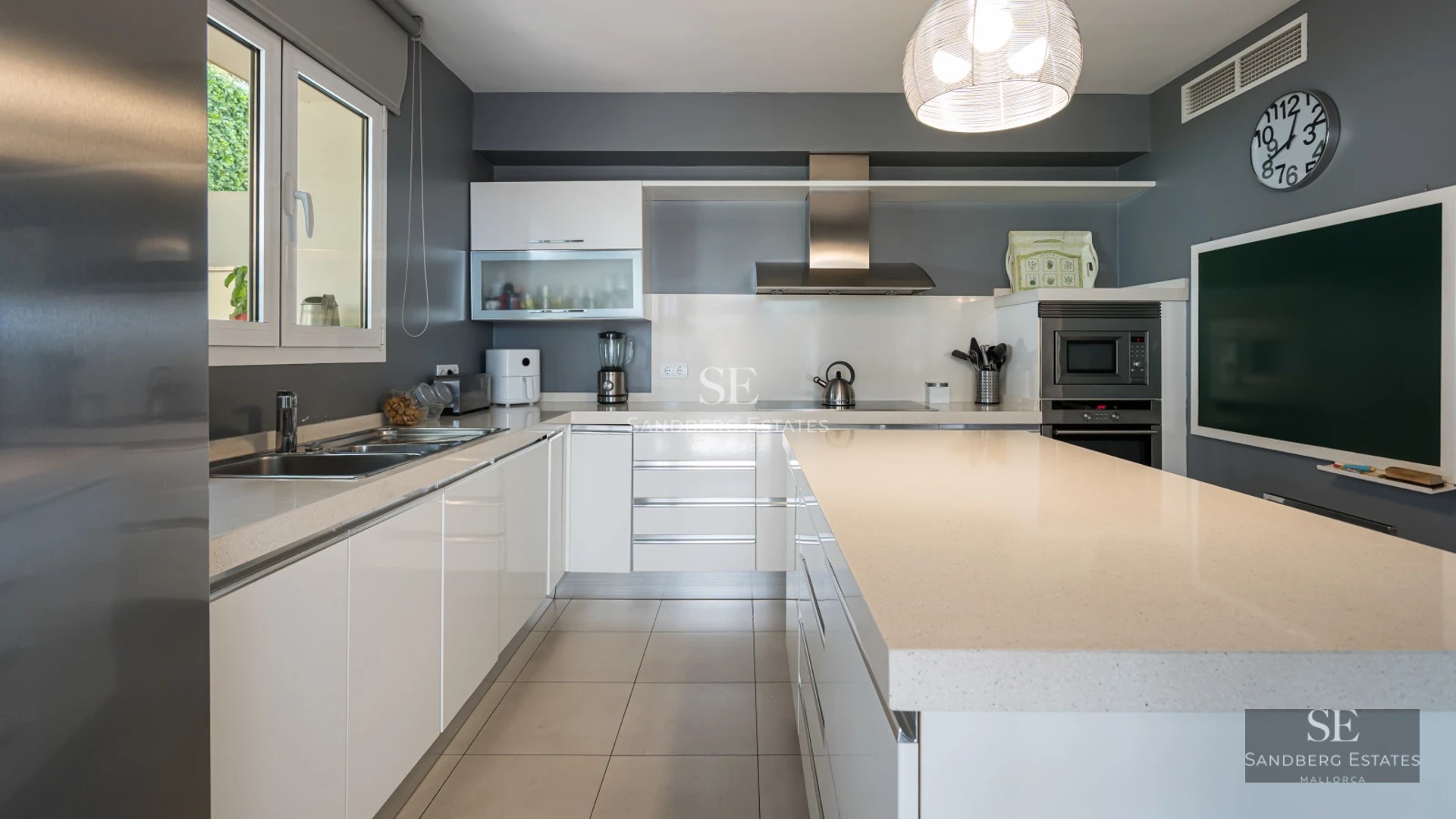 Exterior view of a modern villa featuring an infinity pool, furnished terrace, and lush greenery. Contemporary architectural design.