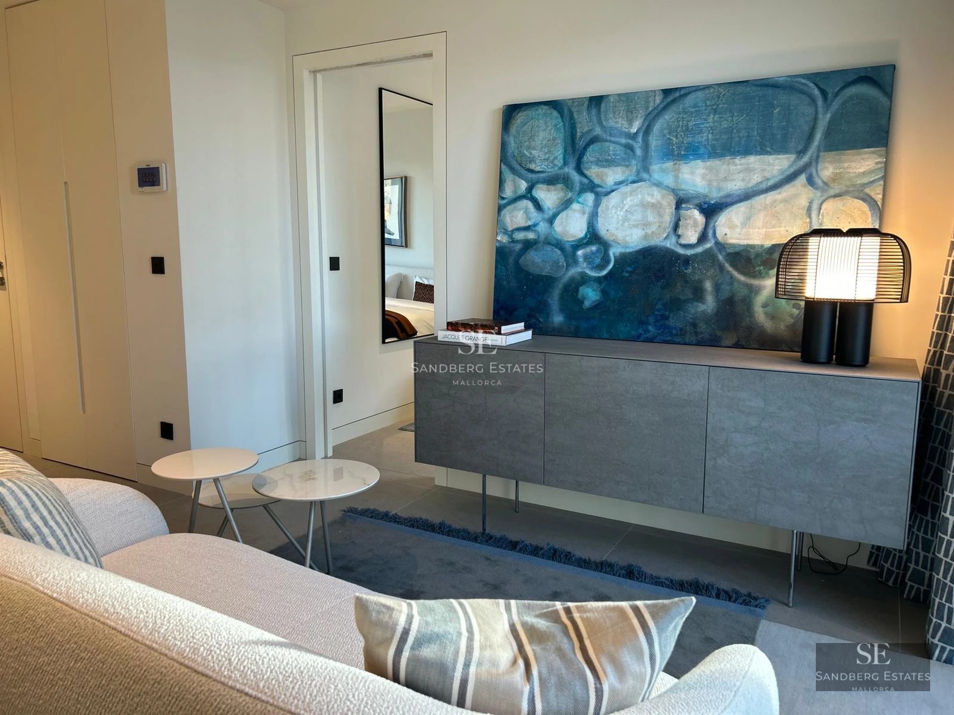 Modern facade with reflecting pool, large windows, minimalist landscaping and ambient lighting.