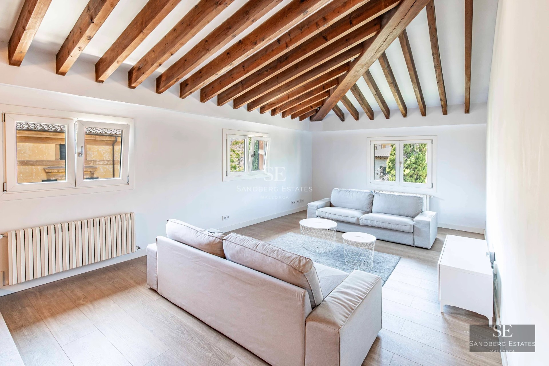 Bright living room with large windows, modern furniture, and access to a terrace. Panoramic views. Minimalist decoration.