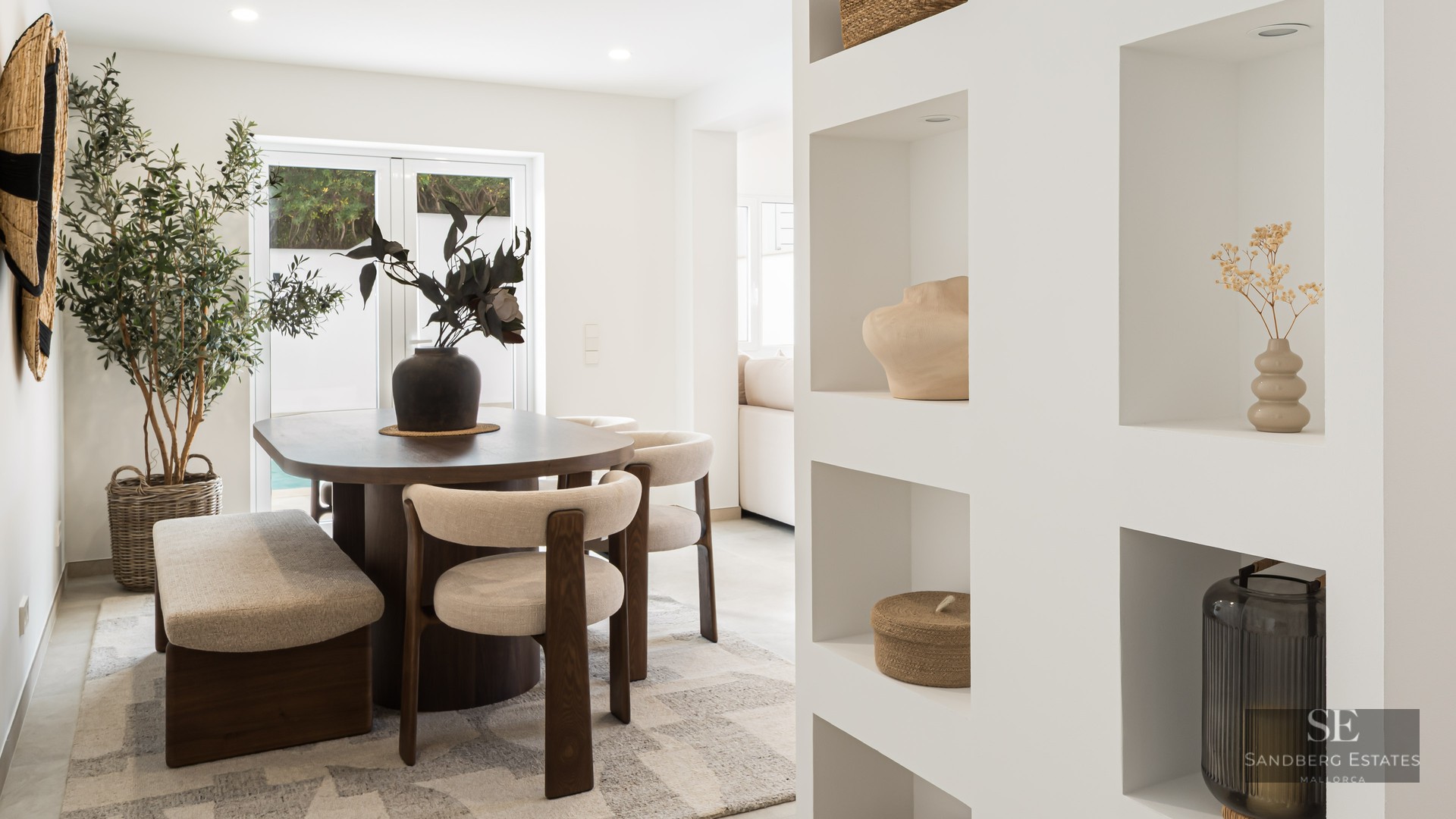 Contemporary dining room featuring a dark wood table, cream chairs, and white built-in wall niches.