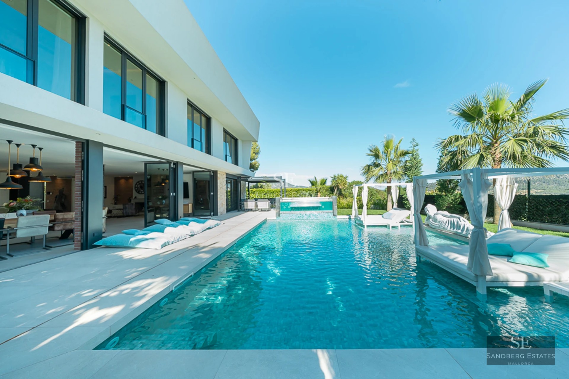 Exterior view of a modern villa with a pool, garden, and spacious terraces. Sleek design and high-quality finishes.