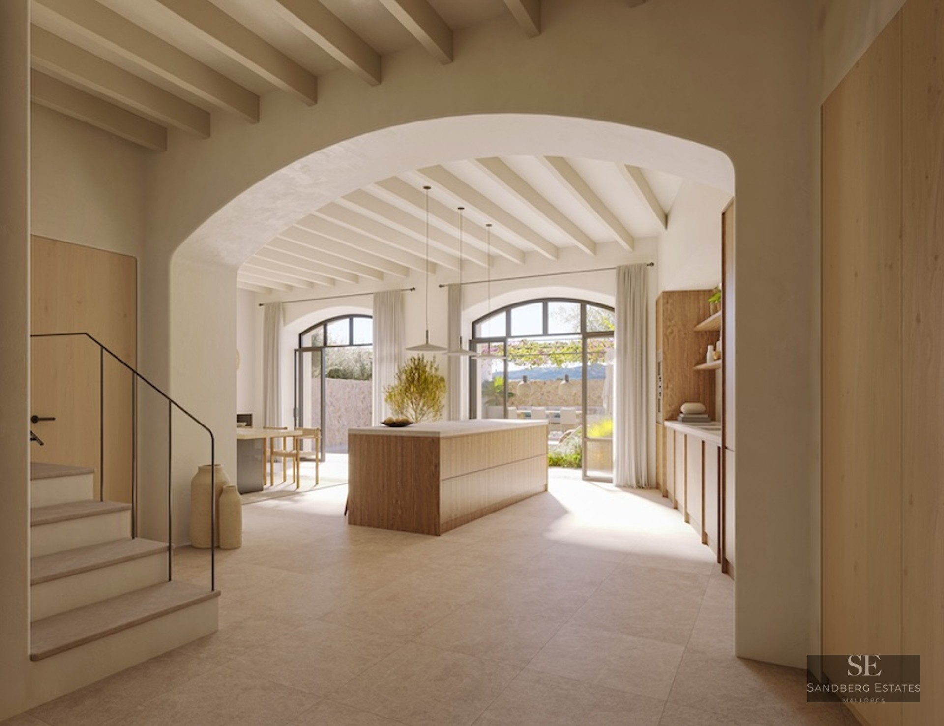 Minimalist kitchen with wooden island, beamed ceiling, and large arched doors opening to a terrace.