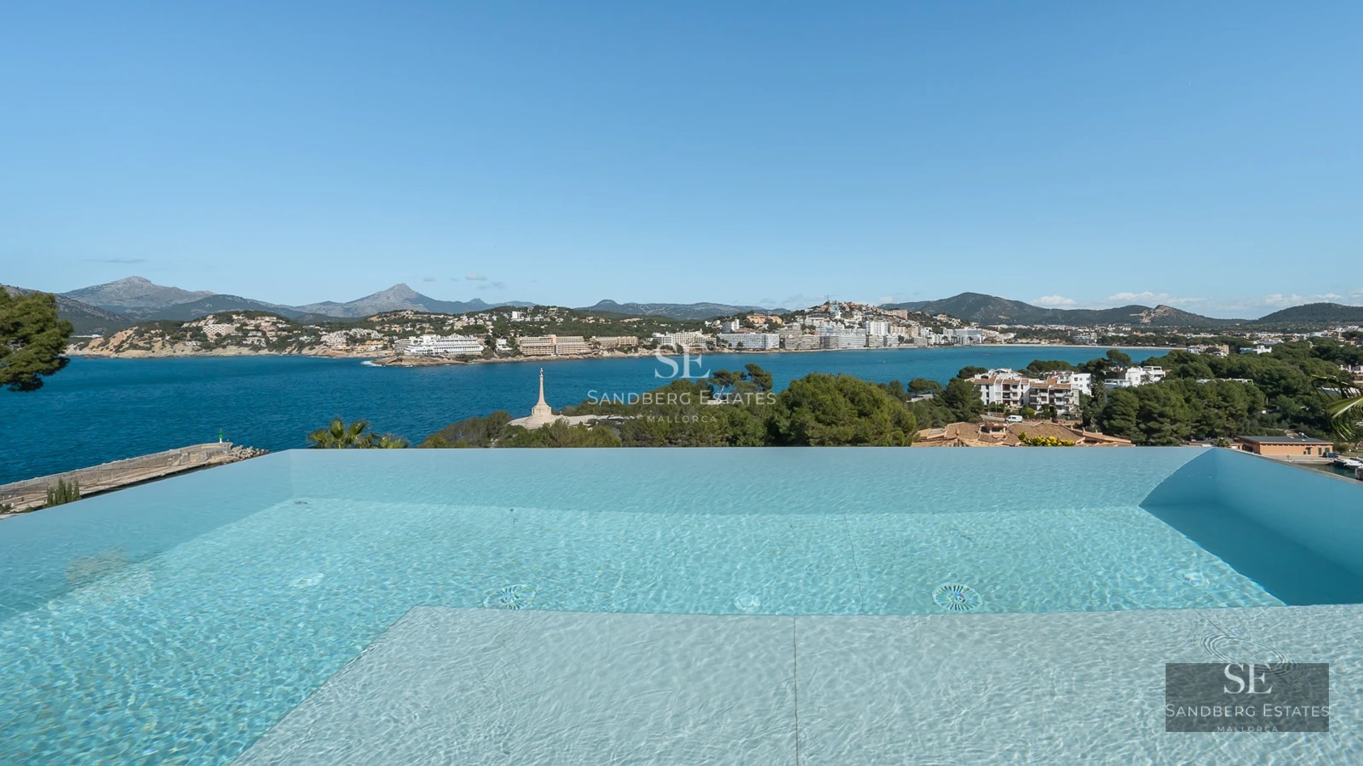 Spacious terrace with swimming pool, sun loungers, and seating area. Modern design with garden view. Ambient lighting.