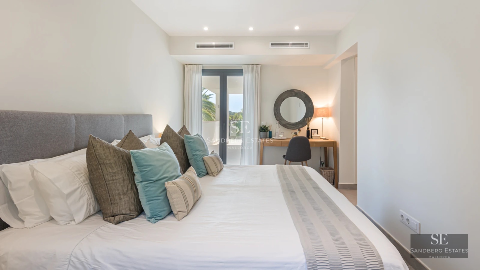 Spacious balcony with panoramic sea views. Modern furniture, light wood floors, and glass railings. Abundant natural lighting.