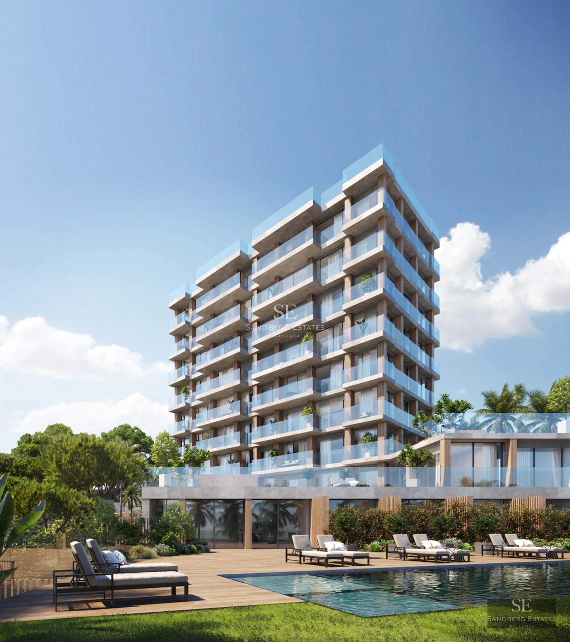 Spacious balcony with sea view from a luxurious modern apartment. Glass railing, stylish outdoor furniture, and blue sky.