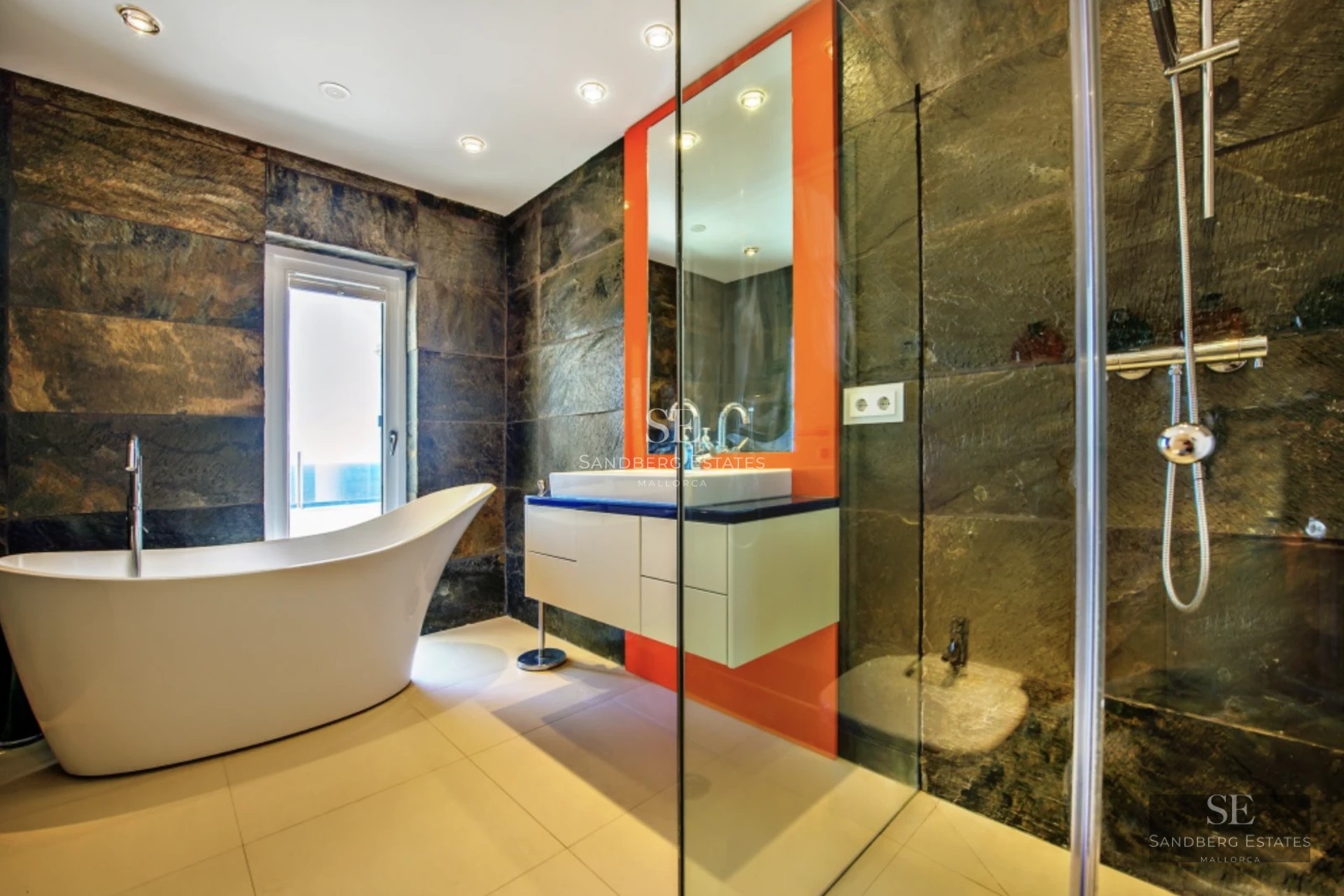 Spacious living room featuring large windows, panoramic sea views, light wood floors, and modern minimalist furniture.