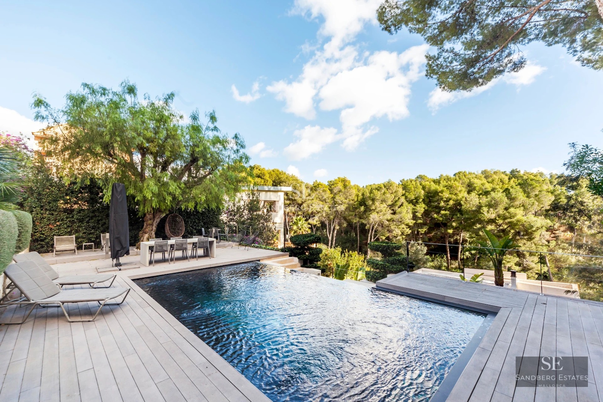 Spacious pool surrounded by lush garden and modern architecture. Panoramic views and exclusive design details.