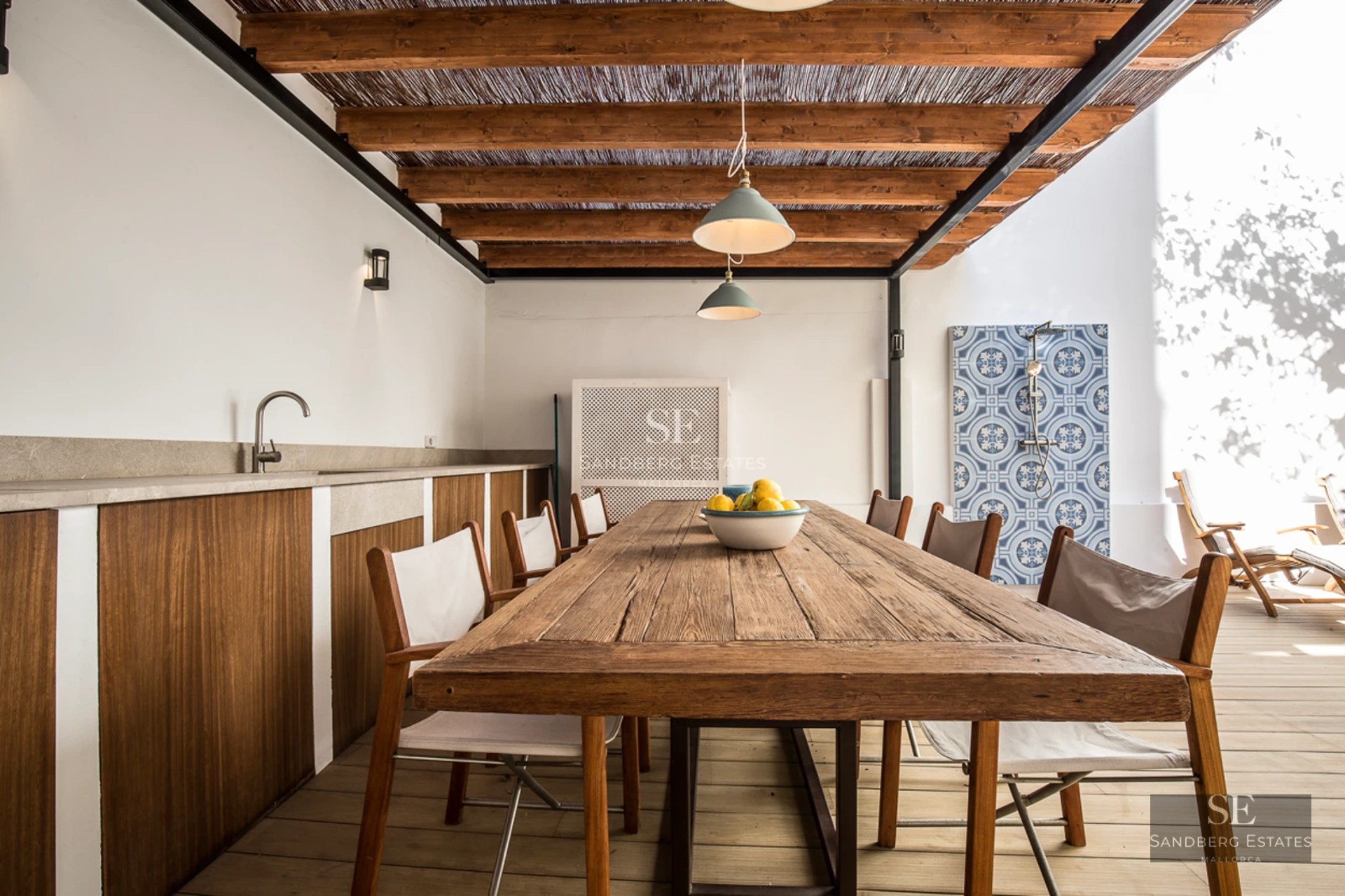 View of a luxury infinity pool with sun loungers. Modern architecture with large windows and lush gardens.