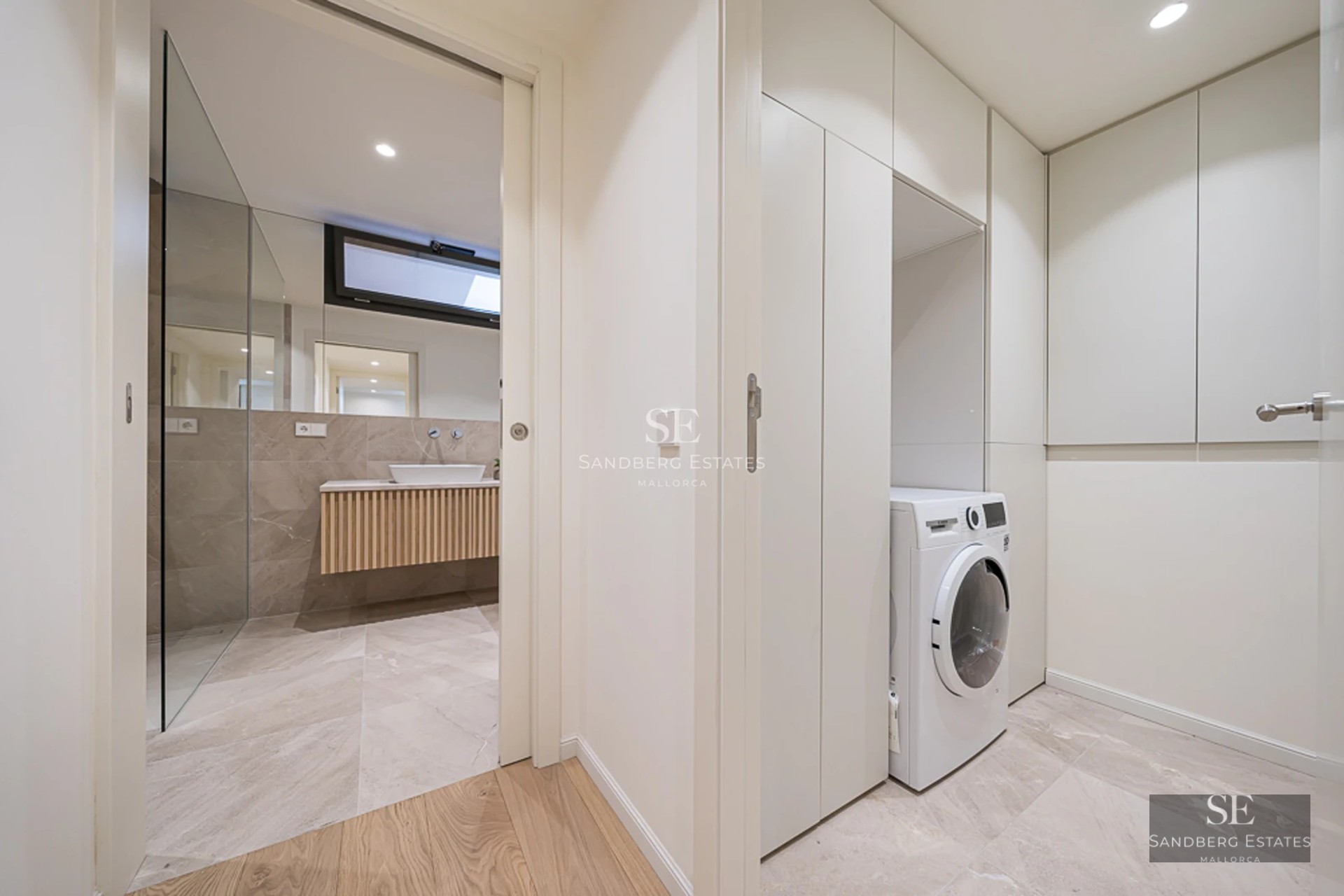 Spacious living room with panoramic windows, modern fireplace, light wood floors and designer furniture. Breathtaking views of the surroundings.