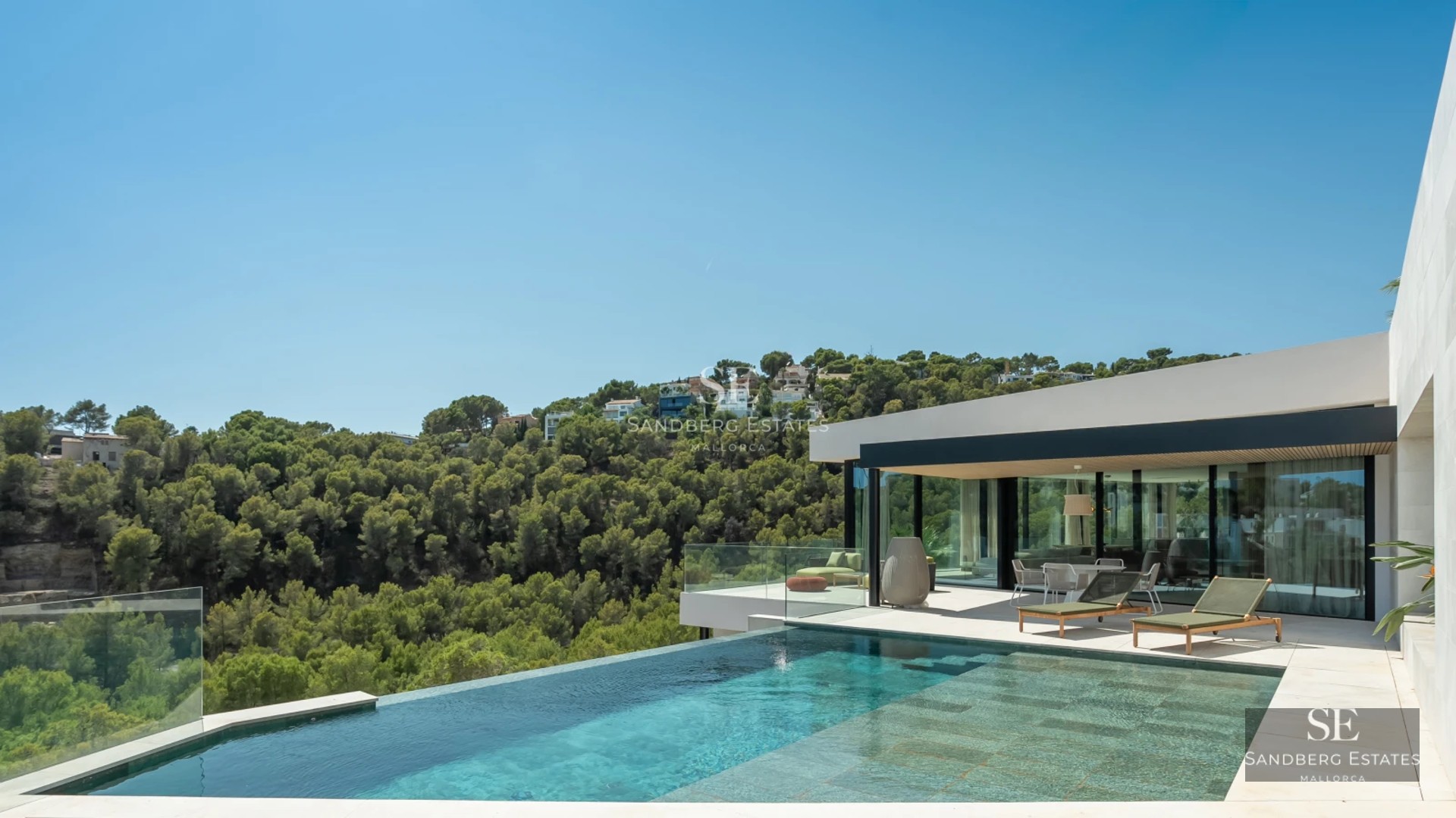 View of a modern villa with infinity pool, terrace, and large windows. Minimalist design with high-quality finishes.