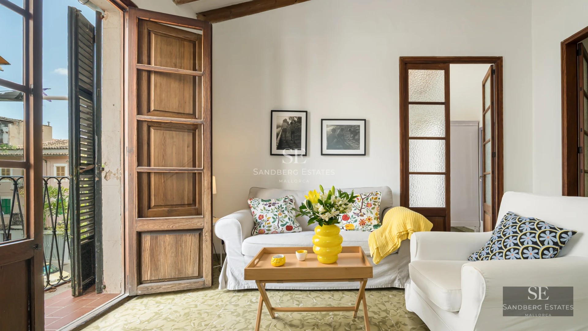 View of infinity pool with glass railings and lush garden, part of a luxurious, modern villa with sea views.