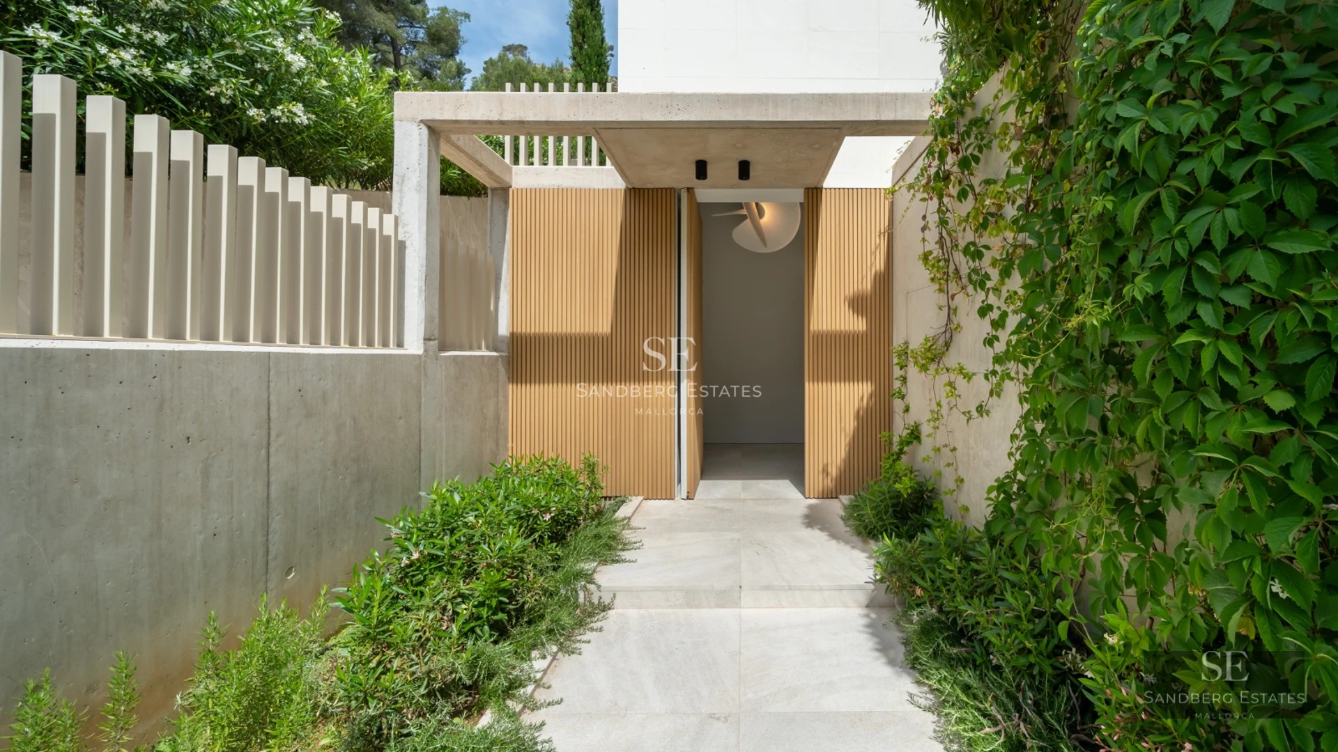 Exterior view of a modern villa with an infinity pool, lush garden, and minimalist architecture.
