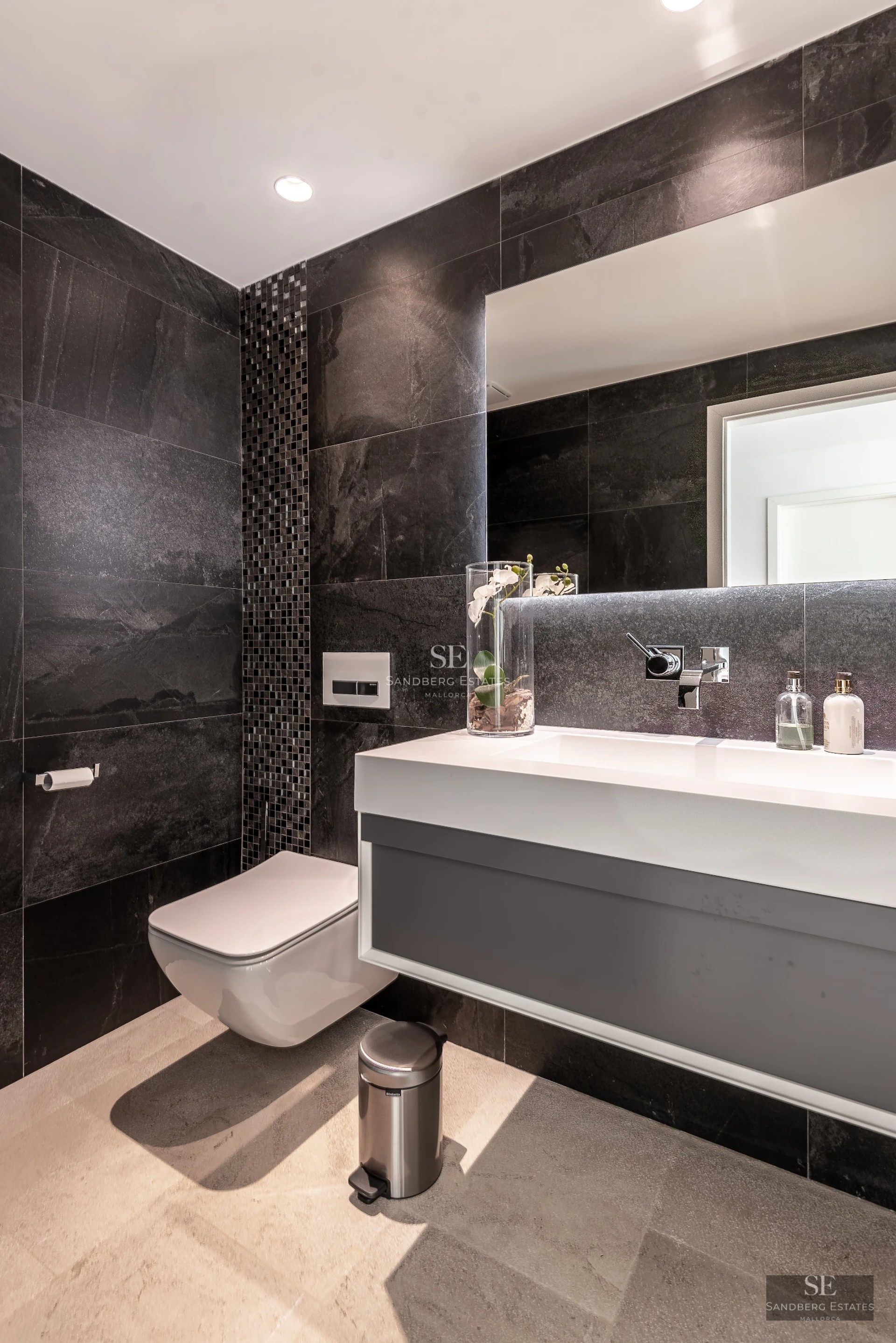 Spacious living room with large windows, leather sofas, modern rug and panoramic views. Warm and elegant lighting.