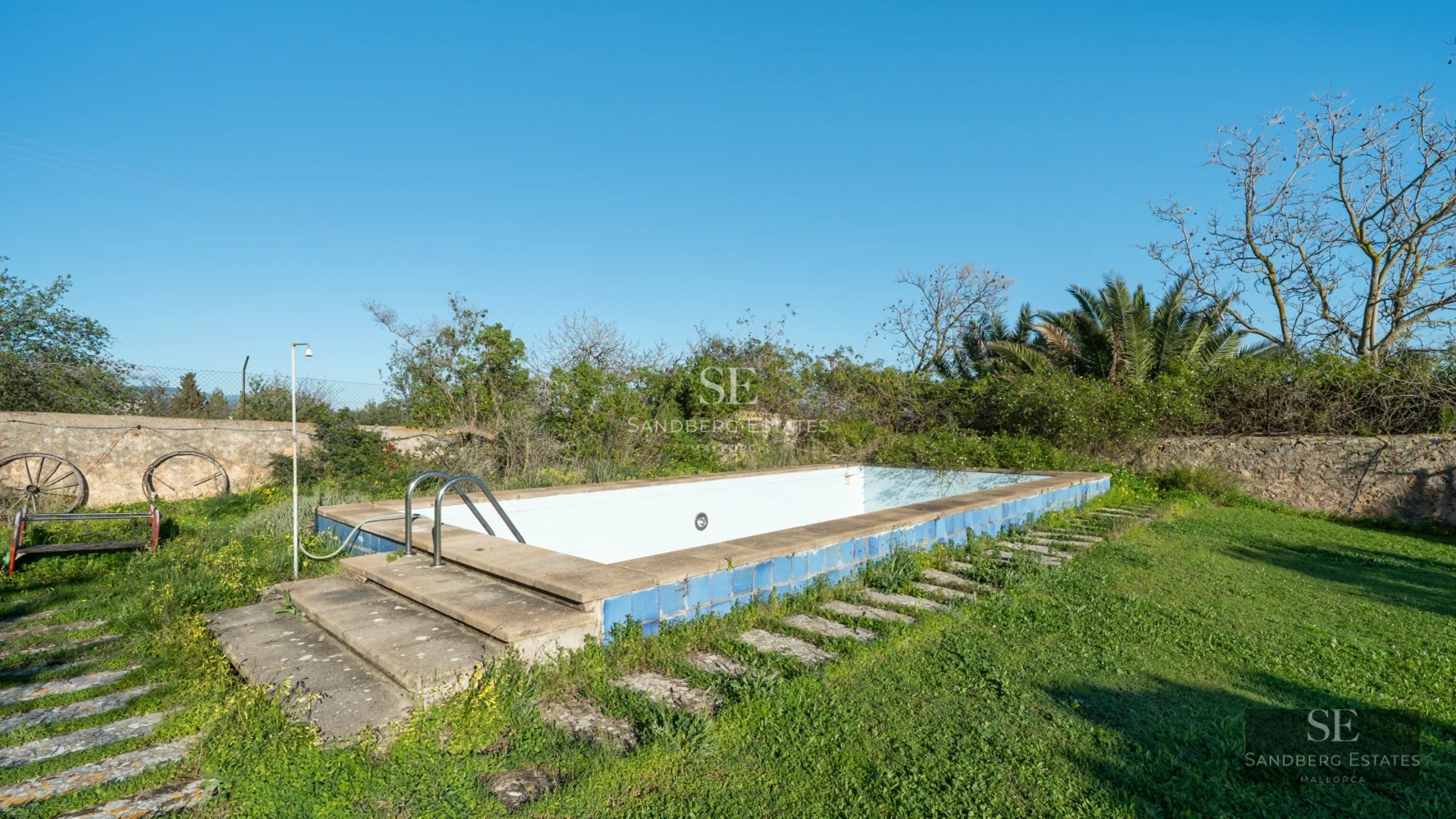 View of a luxury villa with an infinity pool, lush garden, and modern architecture. High-quality finishes and impeccable design.