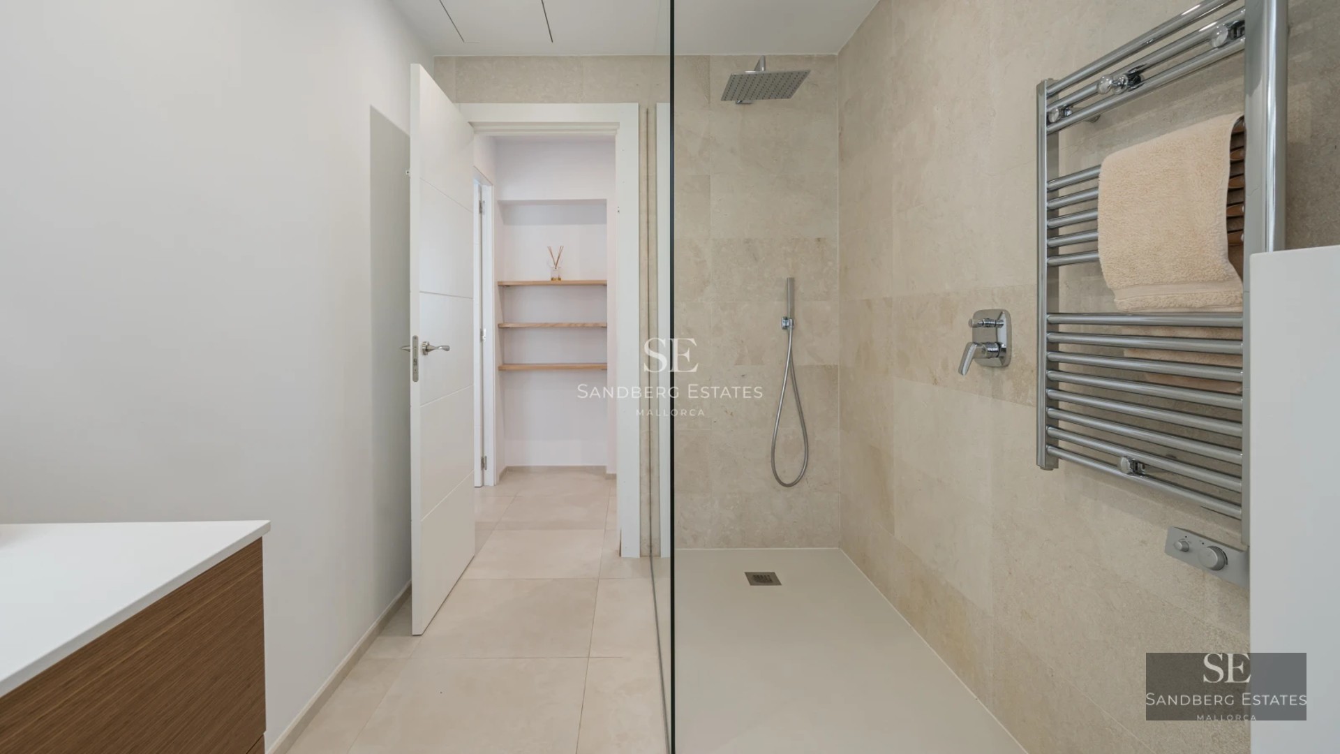 Spacious balcony with panoramic sea views. Modern outdoor furniture. Glass railing. Decorative plants. Wooden floors.