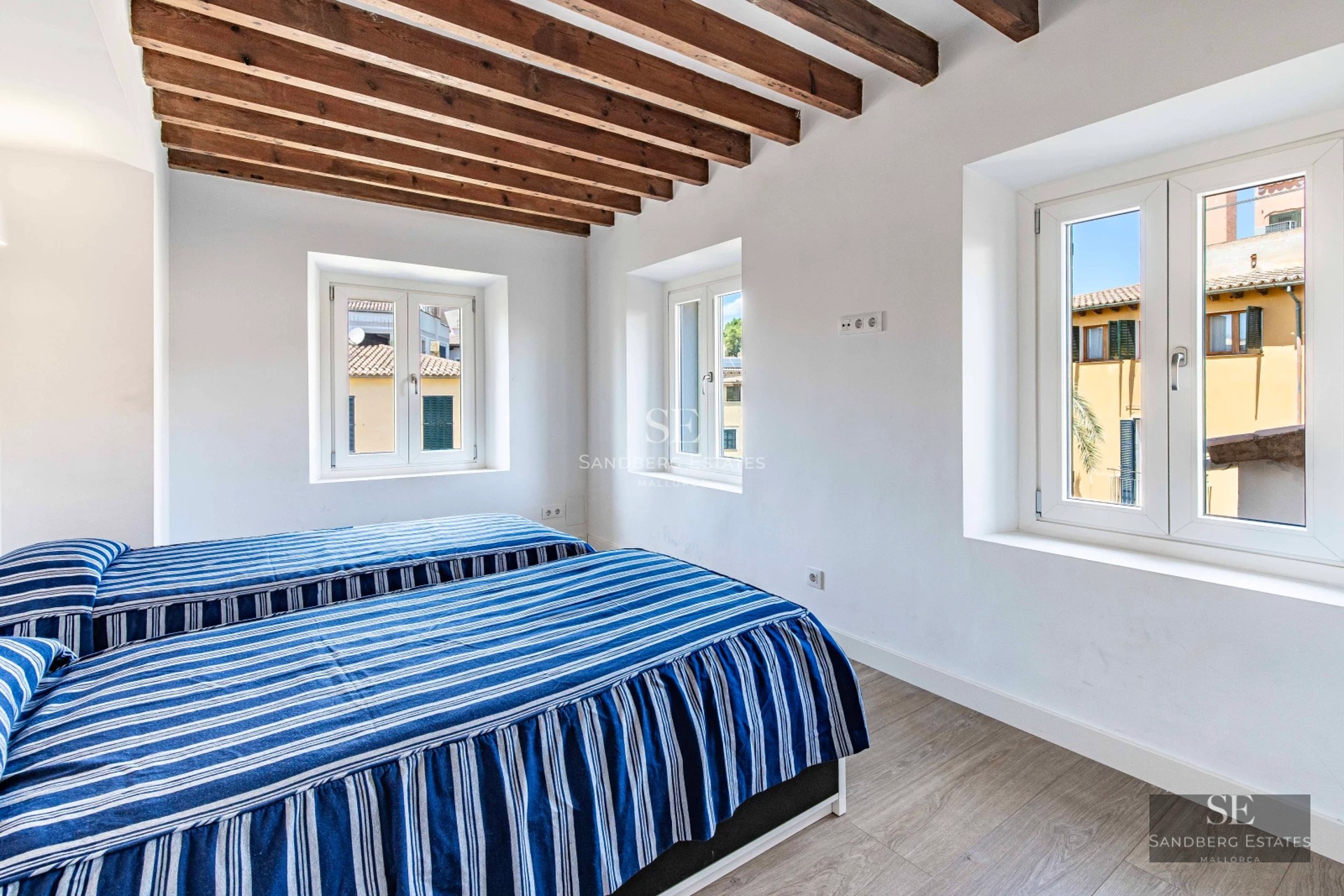 Spacious balcony with panoramic sea view. Modern design, wooden floors, glass railing. Elegant outdoor furniture.