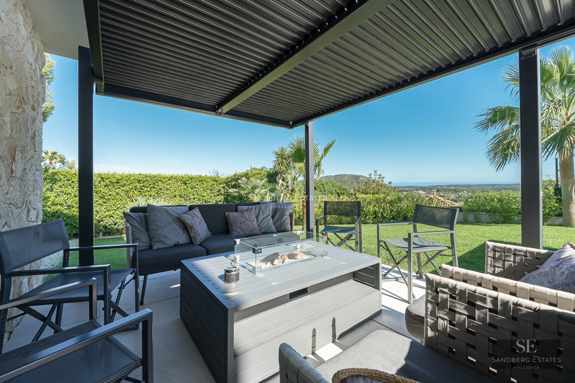 Spacious balcony with panoramic sea views. Modern, minimalist design with glass railing and outdoor furniture.