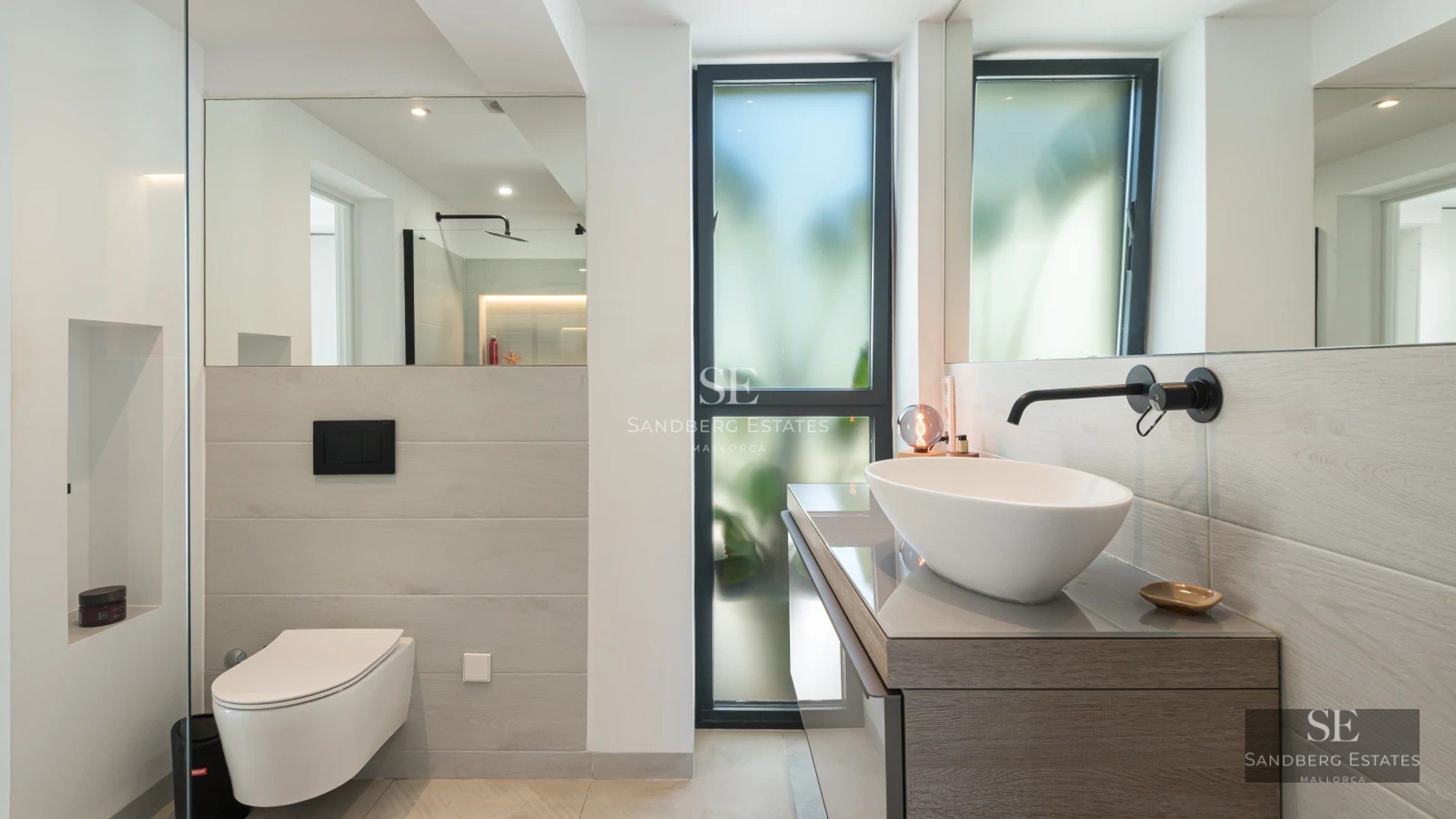 View of infinity pool with lounge chairs and facade of modern villa with minimalist design. Large windows, lush vegetation.