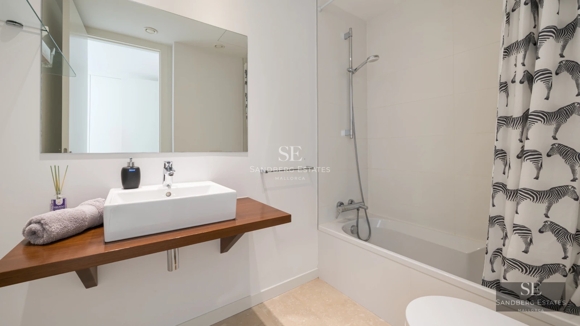 Aerial view of modern villa with infinity pool, manicured garden, and minimalist architectural design featuring clean lines.