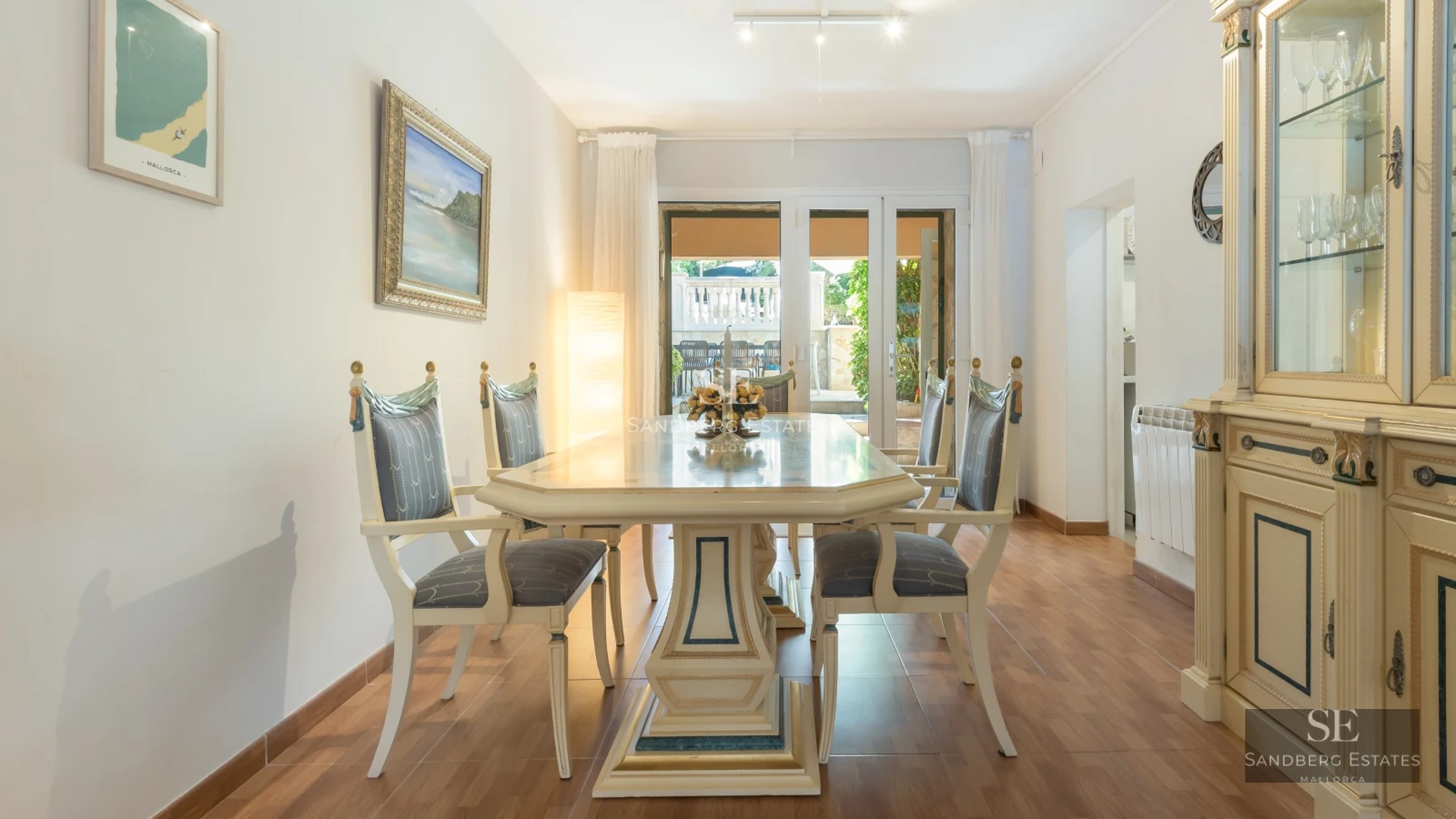 Spacious living room with infinity pool visible through large windows. Modern design, natural light, and hardwood floors.