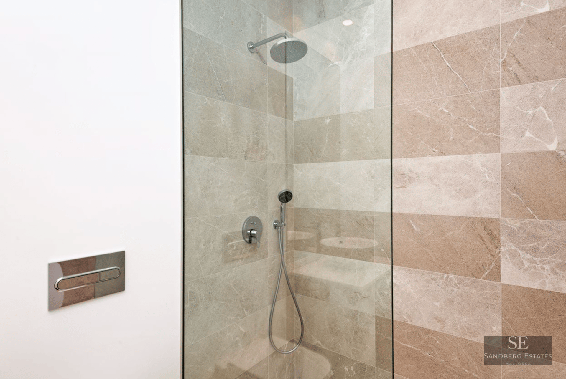 Walk-in shower with rain head, glass screen, and beige stone wall tiles.