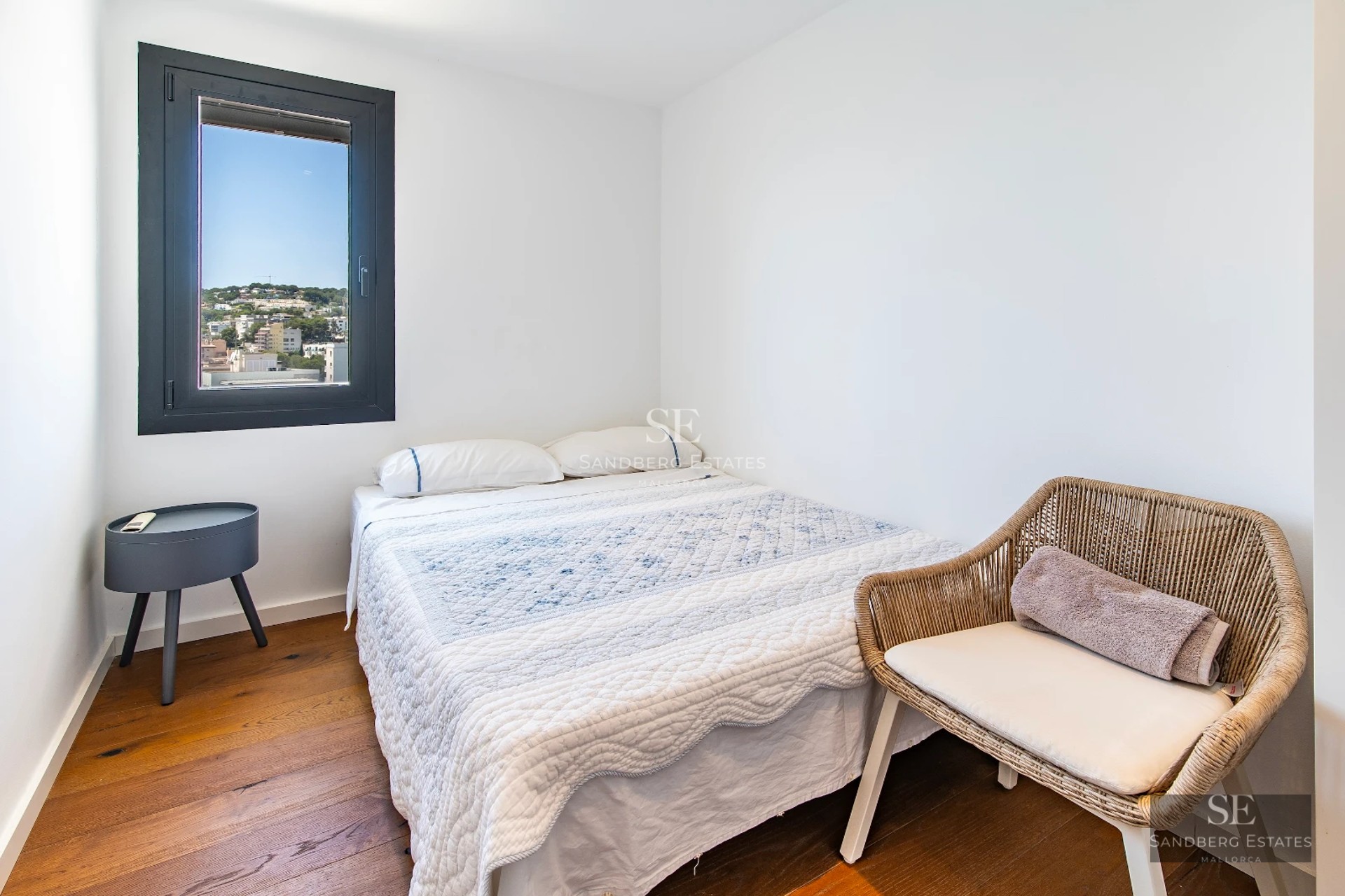 View of a modern infinity pool with panoramic views. Sleek design with sun loungers and lush vegetation.