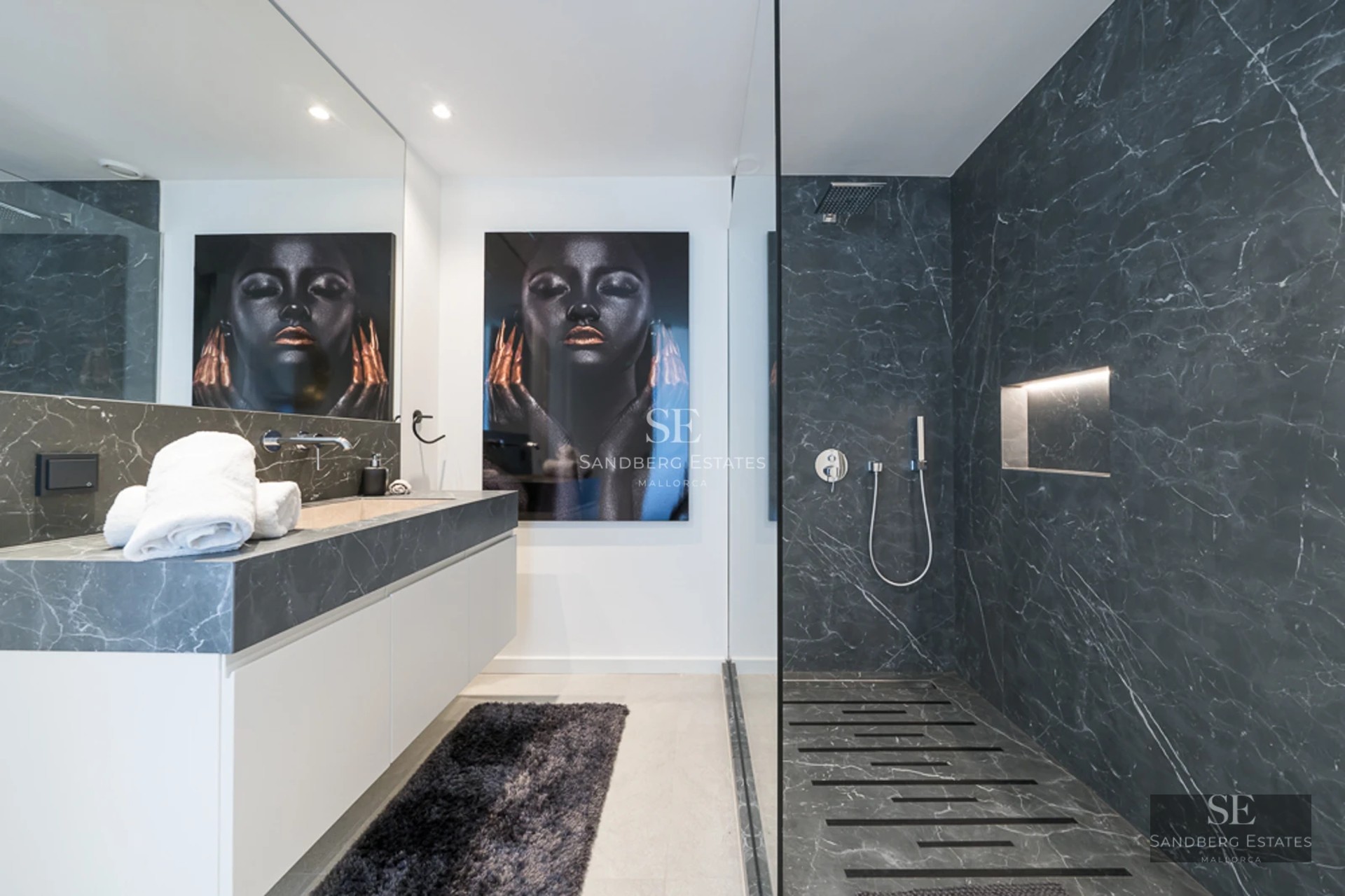 Spacious living room with fireplace, beige sofas, large windows overlooking the garden and abundant natural light. Modern and elegant design.