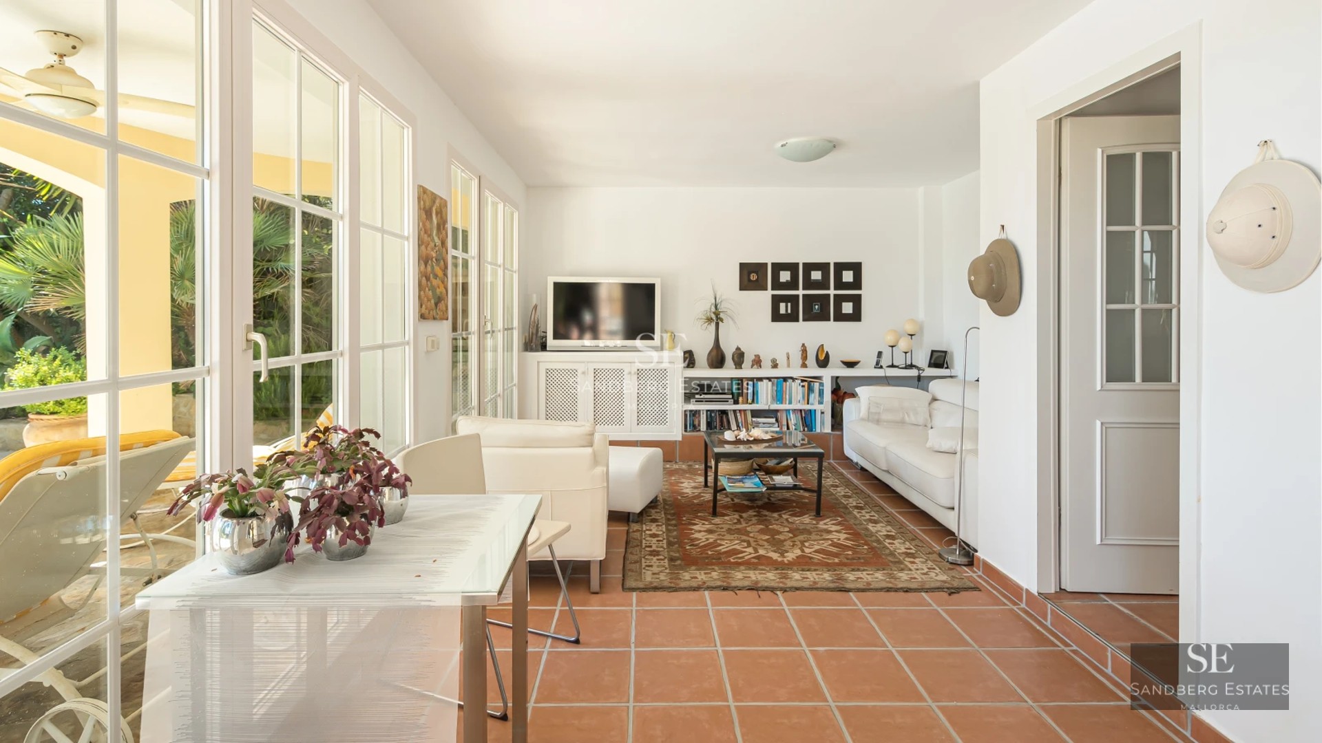 Spacious living room with large windows, light wood floors, gray sofas, and panoramic ocean views. Modern and bright design.