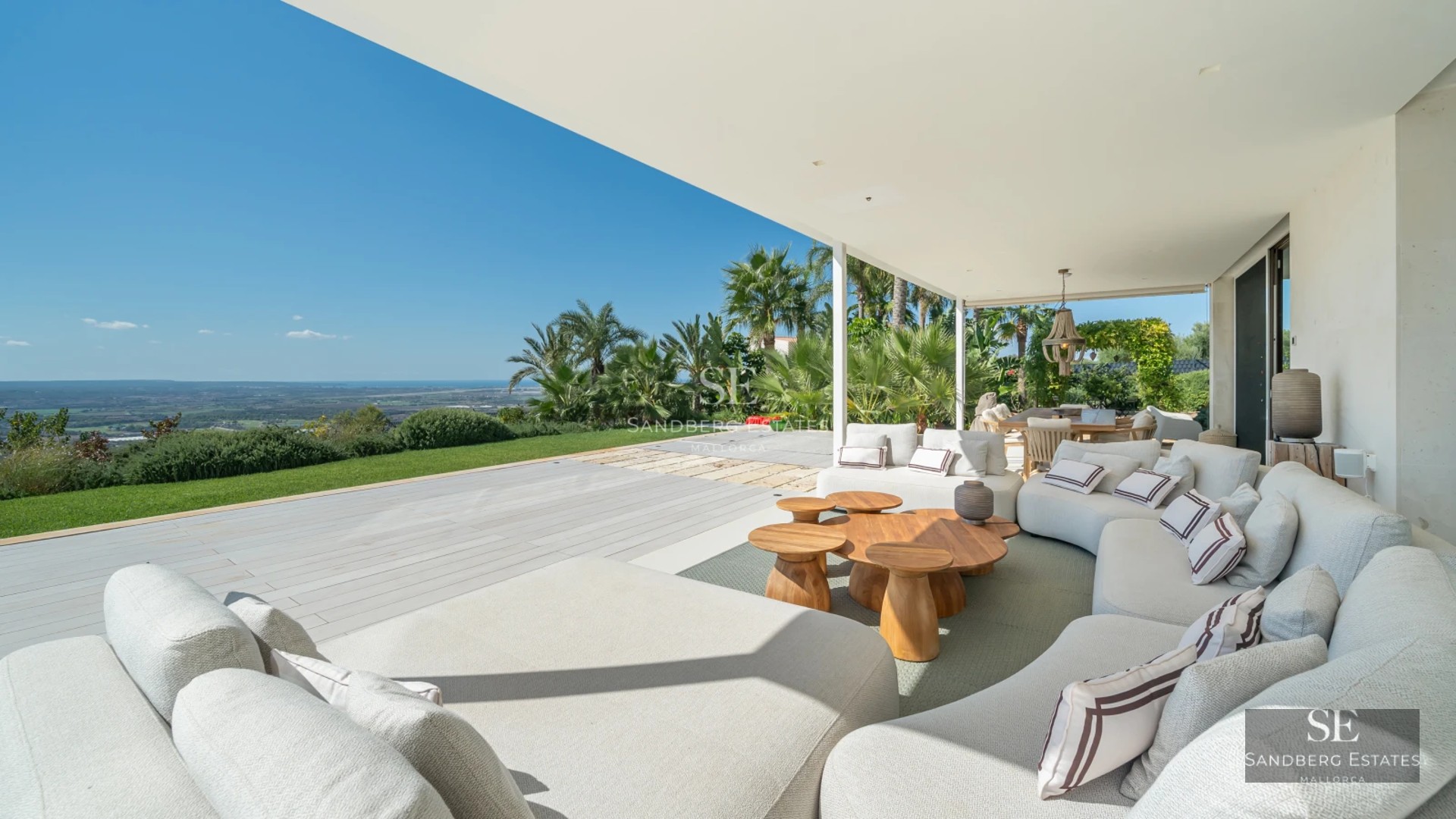 Spacious balcony with panoramic sea views. Modern furniture, glass railing, wood flooring. Ambient lighting. Luxury and comfort.