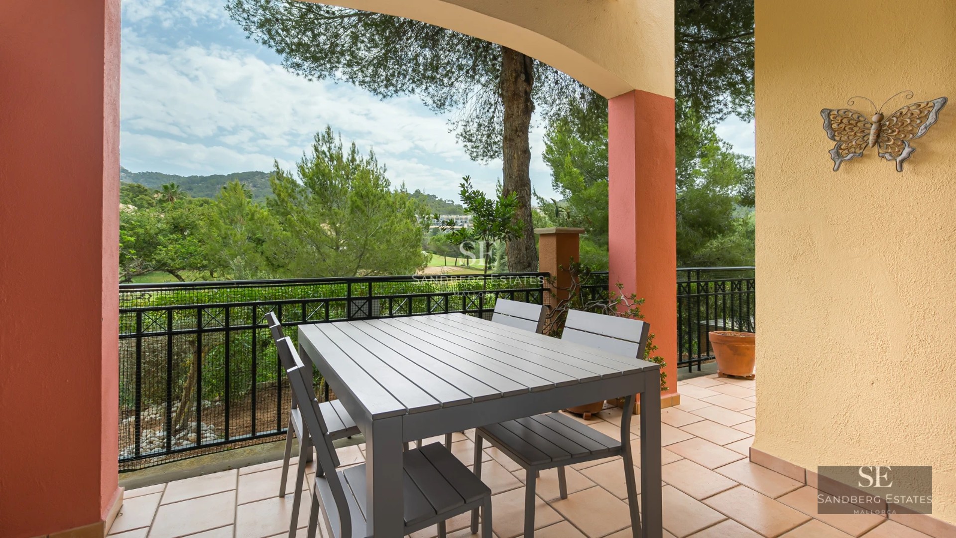 Exterior view of a modern villa with an infinity pool, lush garden, and spacious terraces offering panoramic sea views.