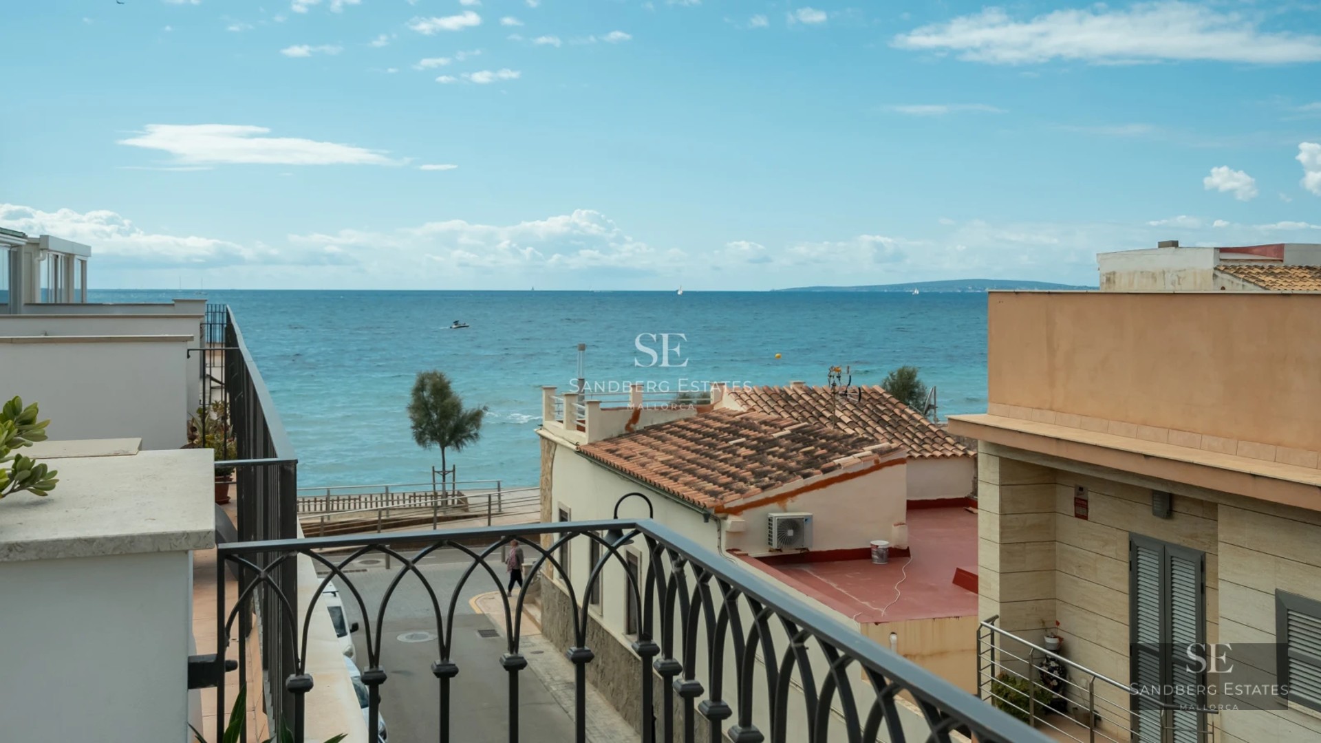 Large swimming pool surrounded by terrace with sun loungers and umbrellas. Elegant landscaping and modern architecture. Well-maintained lawn.