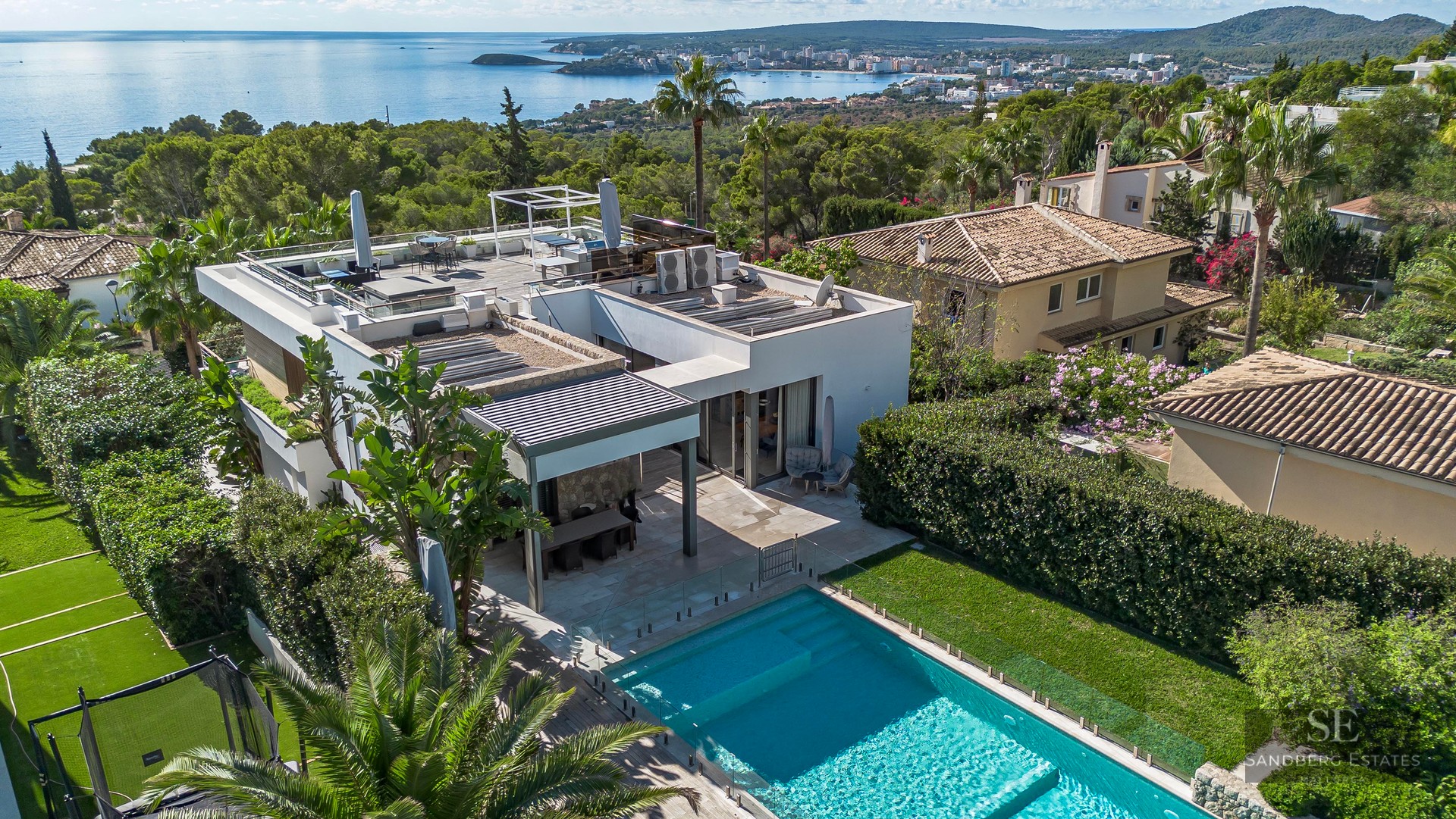 Vue aérienne d'une villa blanche moderne avec piscine, terrasse et vue panoramique sur la mer Méditerranée.