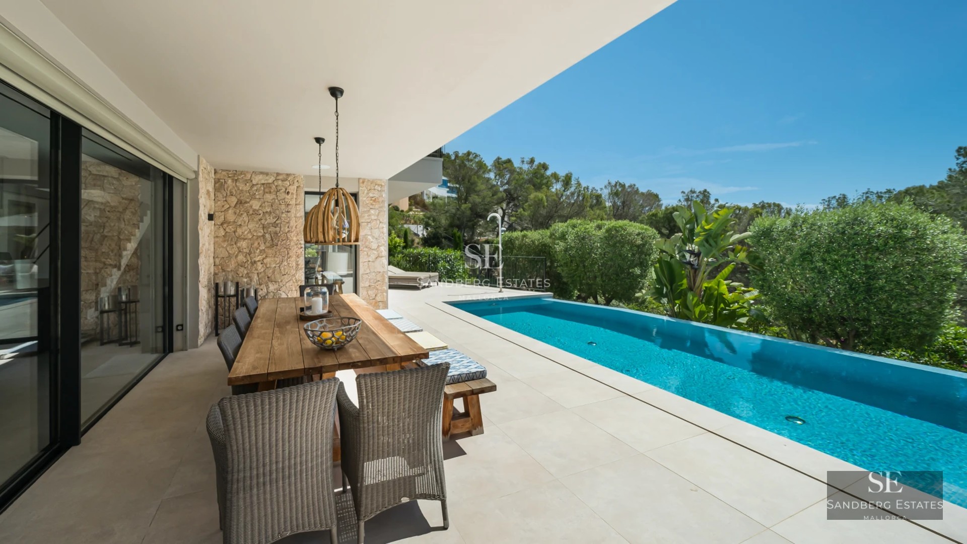 Spacious balcony with panoramic sea views. Modern furniture, glass railing and wooden floor. Elegant and bright design.