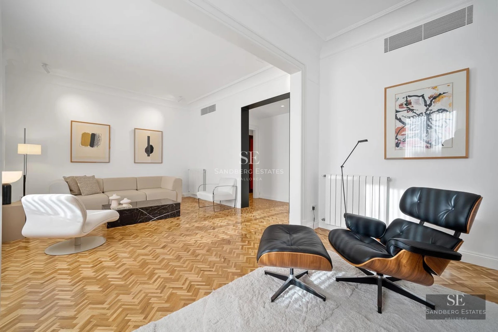 View of a luxury villa with infinity pool, surrounded by greenery. Modern architecture with large windows and high-quality finishes.