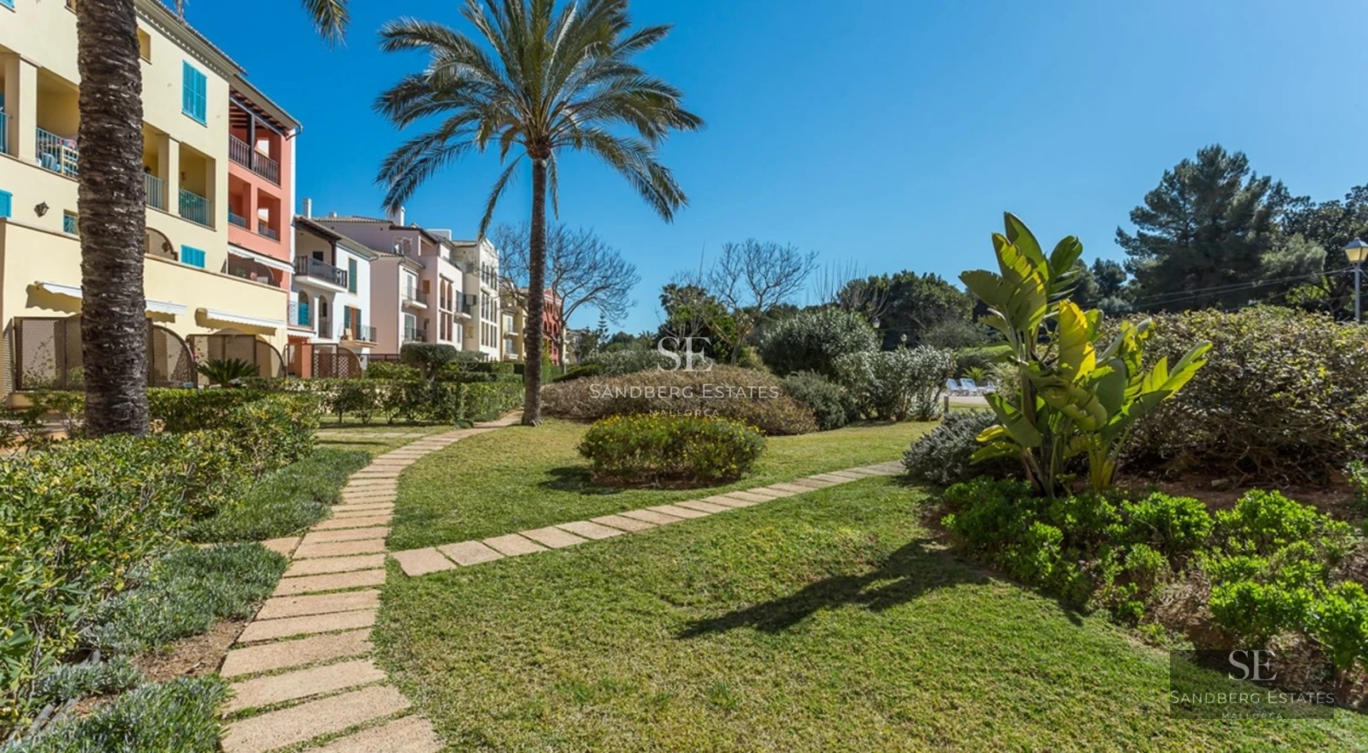 Exterior view of a modern villa featuring a pool, expansive terraces, lush greenery, and minimalist architecture. White facade and large windows.